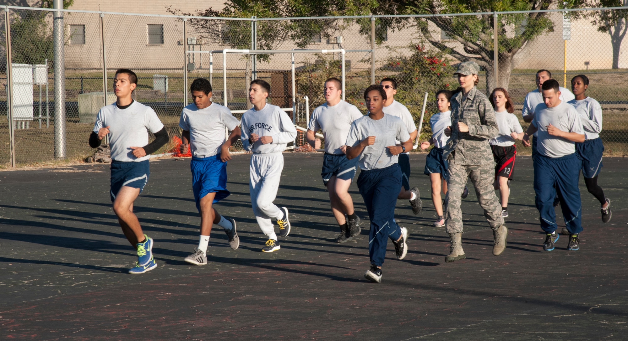 Company Grade Officers' Council members, right, lead part of the Air Force Junior ROTC detachment in a warm up run at Del Rio High School, Texas, Nov. 15, 2013. Each week the CGOs meet to show how important fitness is to the Air Force. (U.S. Air Force photo/2nd Lt. William M. Tyrrell)