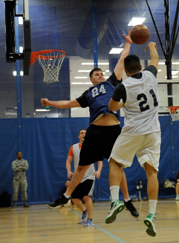 A member from the maintenance team blocks a shot from the opposing team during an intramural basketball game at Fairchild Air Force Base, Wash., Nov. 14, 2013. There are 10 teams competing against each other for the championship. (U.S. Air Force photo by Airman 1st Class Ryan Zeski/Released)