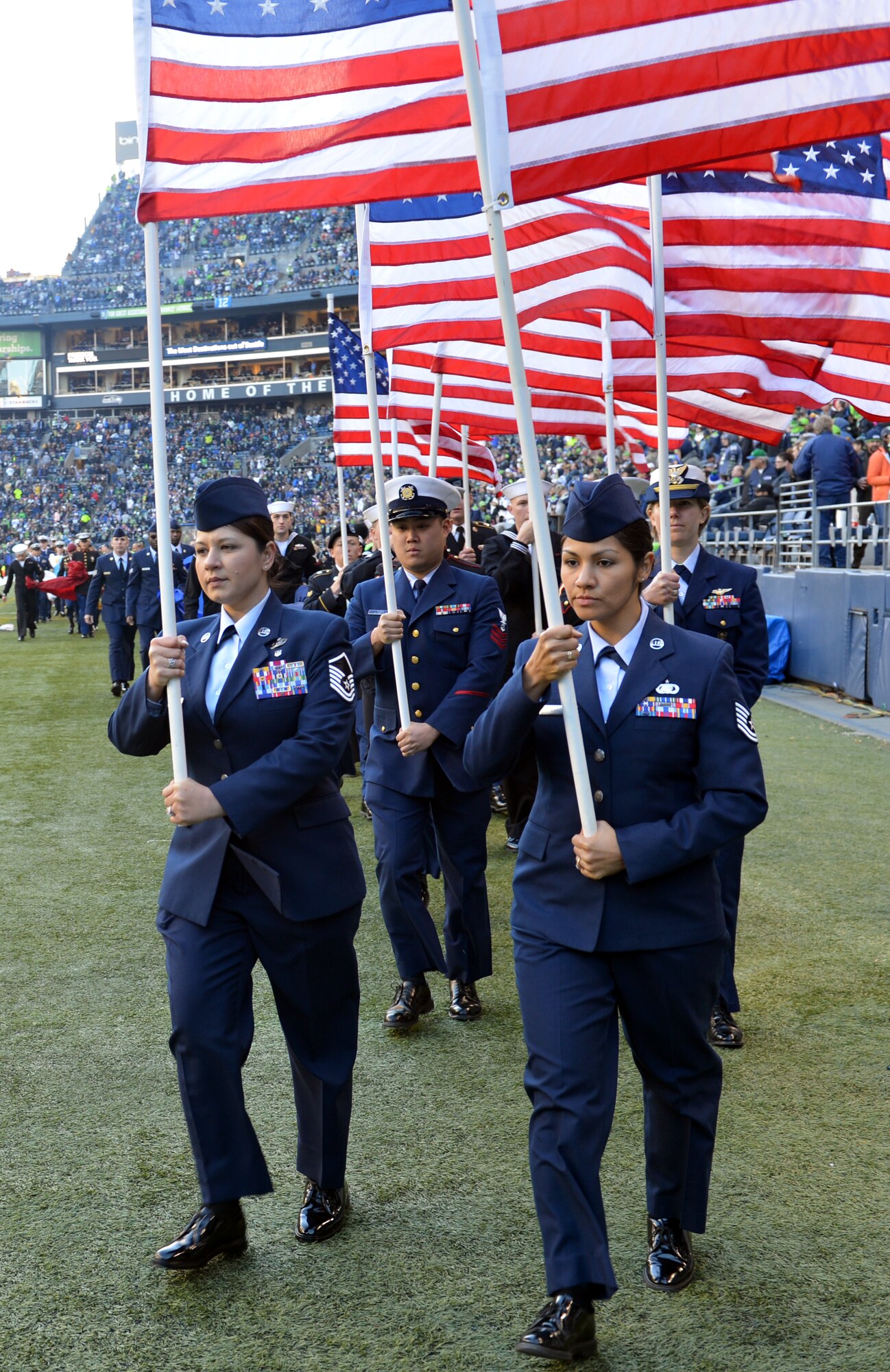 Members of Air Force, Army, Coast Guard, Marines, and Navy march off the football field with American flags following the halftime “Salute to Service” ceremony at Safeco Field, Jan. 17, 2013 in Seattle, Wash. More than 150 military members participated in the Seattle Seahawks “Salute to Service” pregame and halftime ceremonies.. (U.S. Air Force photo/Staff Sgt. Jason Truskowski)