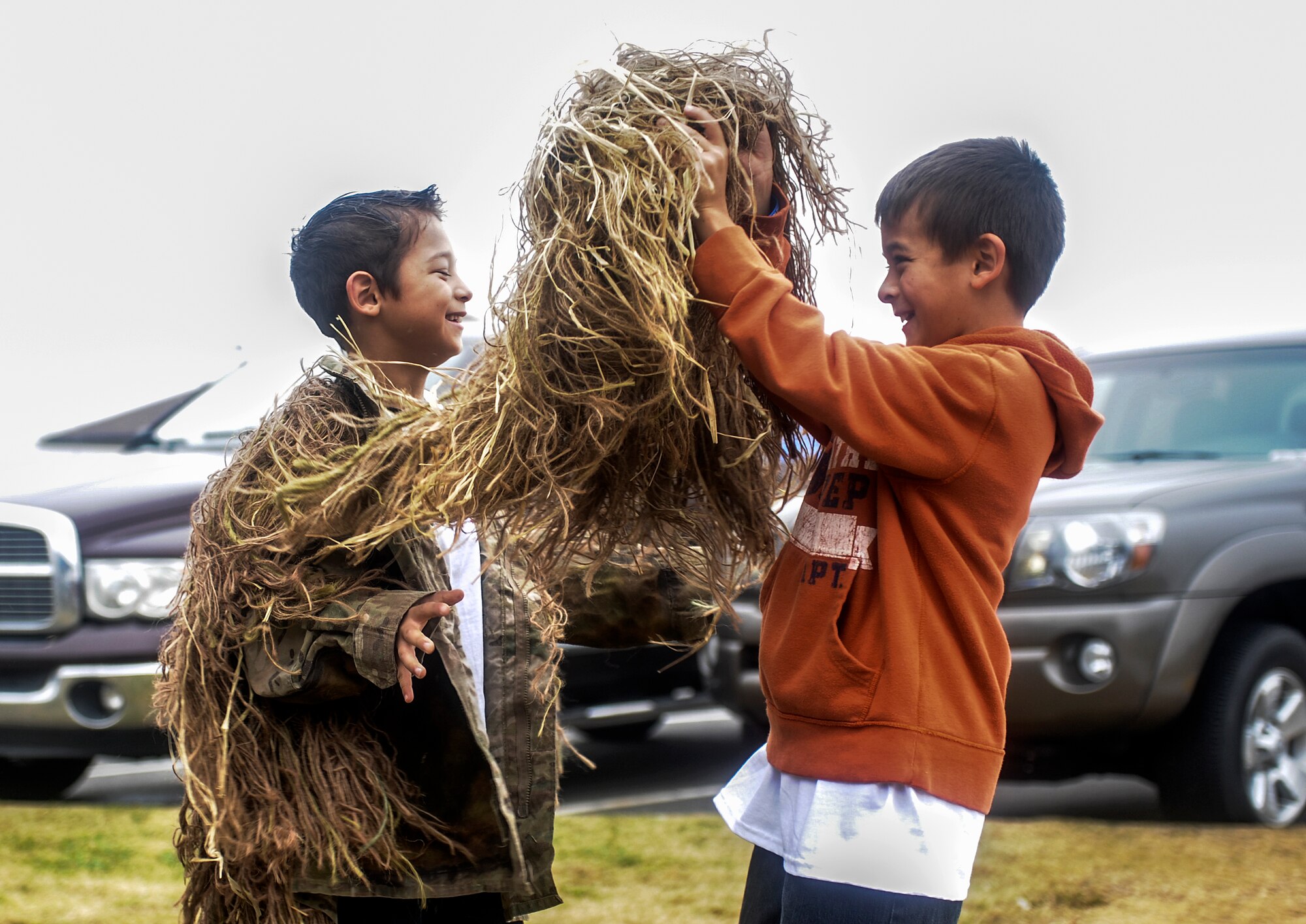 Isaac helps his brother, Ethan, put on a ghillie suit during the Month of the Military Family event Nov. 16, 2013, at Little Rock Air Force Base, Ark. The event lasted from 10:00 a.m. - 2:00 p.m. and featured games, scavenger hunts and mini events to support team building and encourage family participation. (U.S. Air Force photo by Staff Sgt. Jessica Condit)
