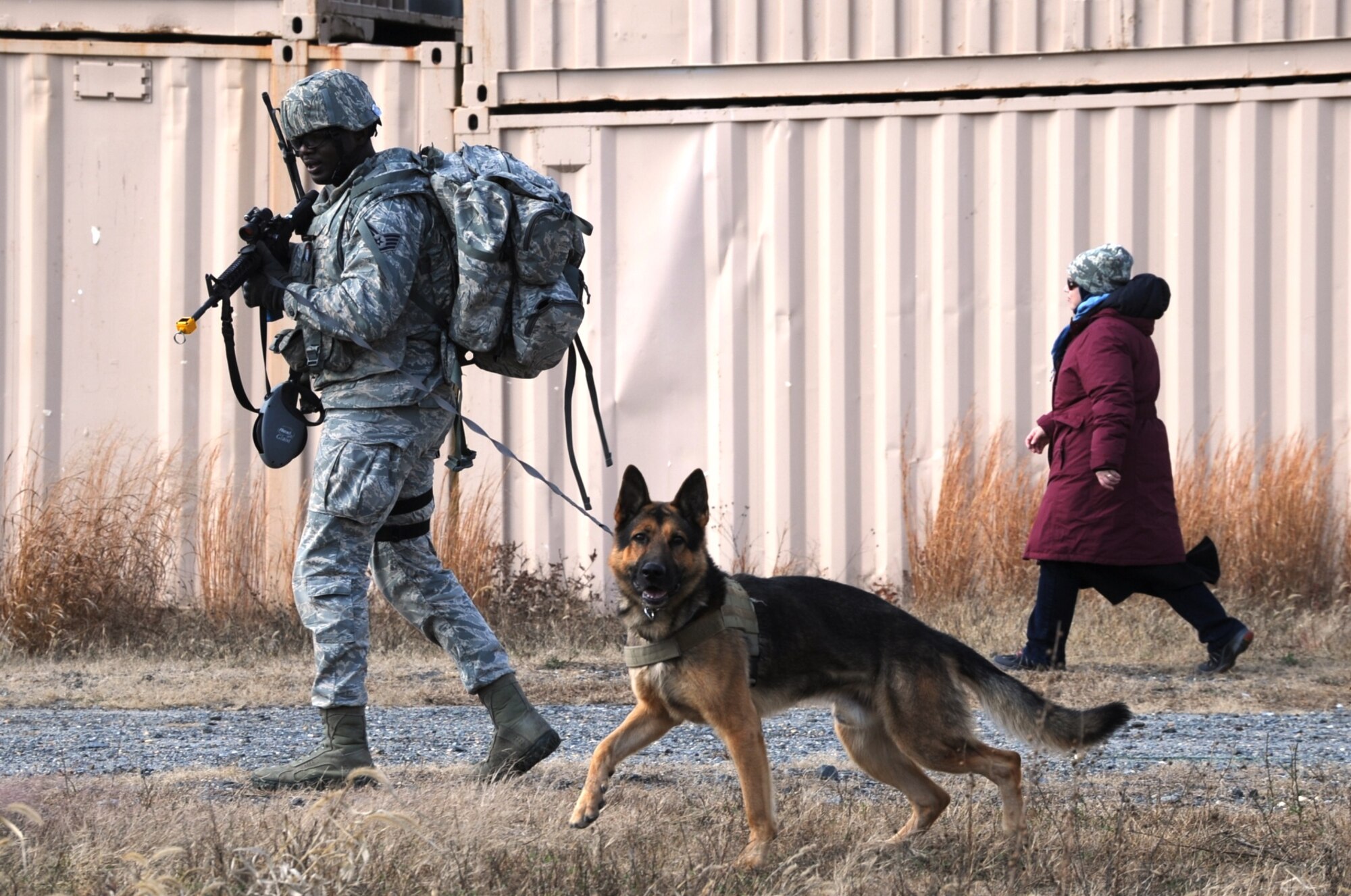 Staff Sgt. Desmond Martin, military working dog handler from Peterson Air Force Base, Colo., performs an explosive sweep in a village with Rocky, a MWD, during the MWD Base Security Operations Course Nov. 10, 2013, at Joint Base McGuire-Dix-Lakehurst, N.J.  (U.S. Air Force photo by Staff Sgt. Nathaniel Bevier/Released)