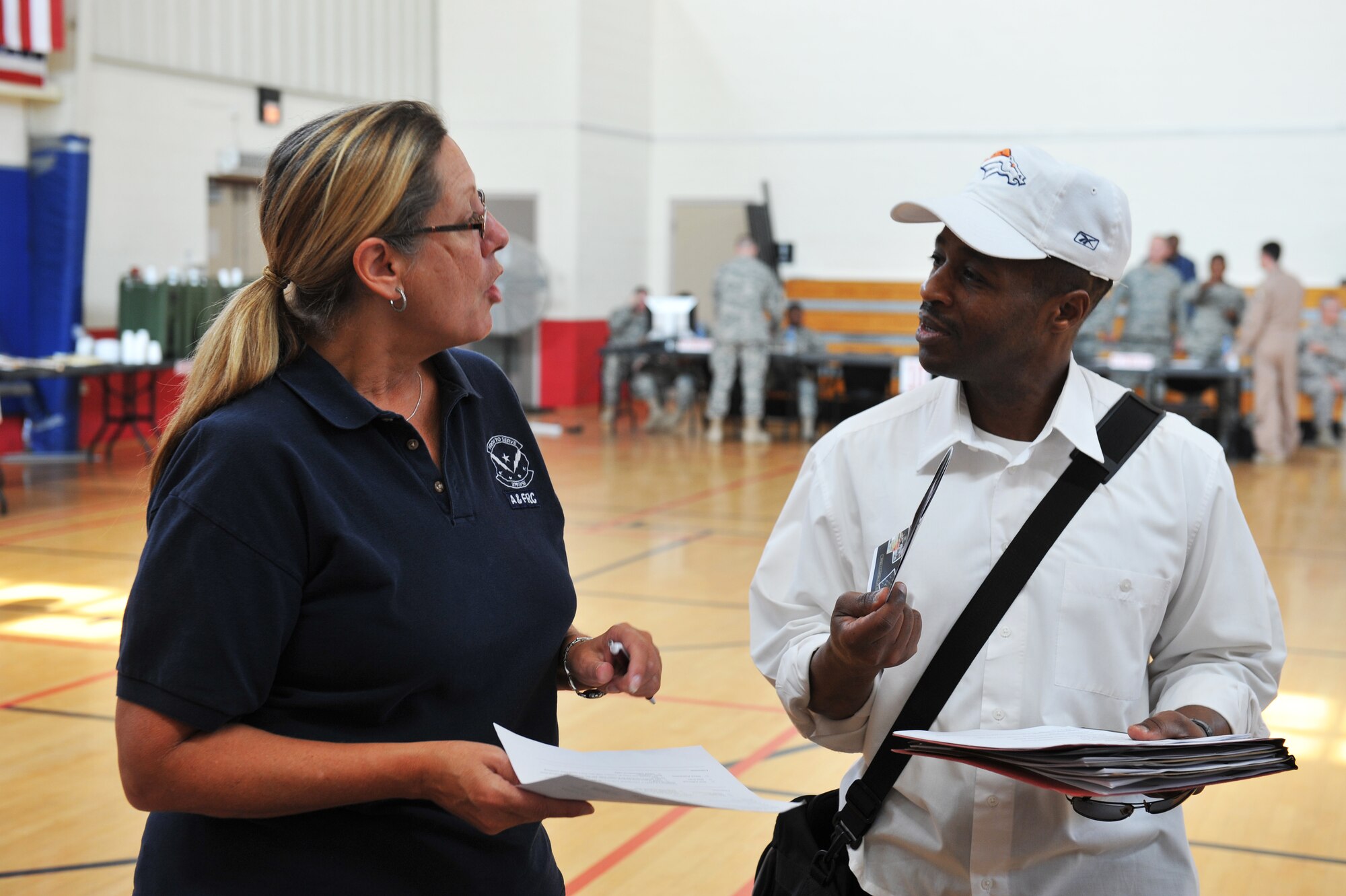 Brenda Wells, 379th Expeditionary Force Support Squadron Airman & Family Readiness Center community readiness consultant, speaks to Patrick Henry, a logistics contracting officer representative, during a noncombatant evacuation operations exercise at an undisclosed location in Southwest Asia, Nov. 16, 2013. A&FRC members assess medical, educational and work needs of individuals and reach out to gaining locations to meet short and long term needs of those newly arriving. (U.S. Air Force photo/Master Sgt. David Miller)