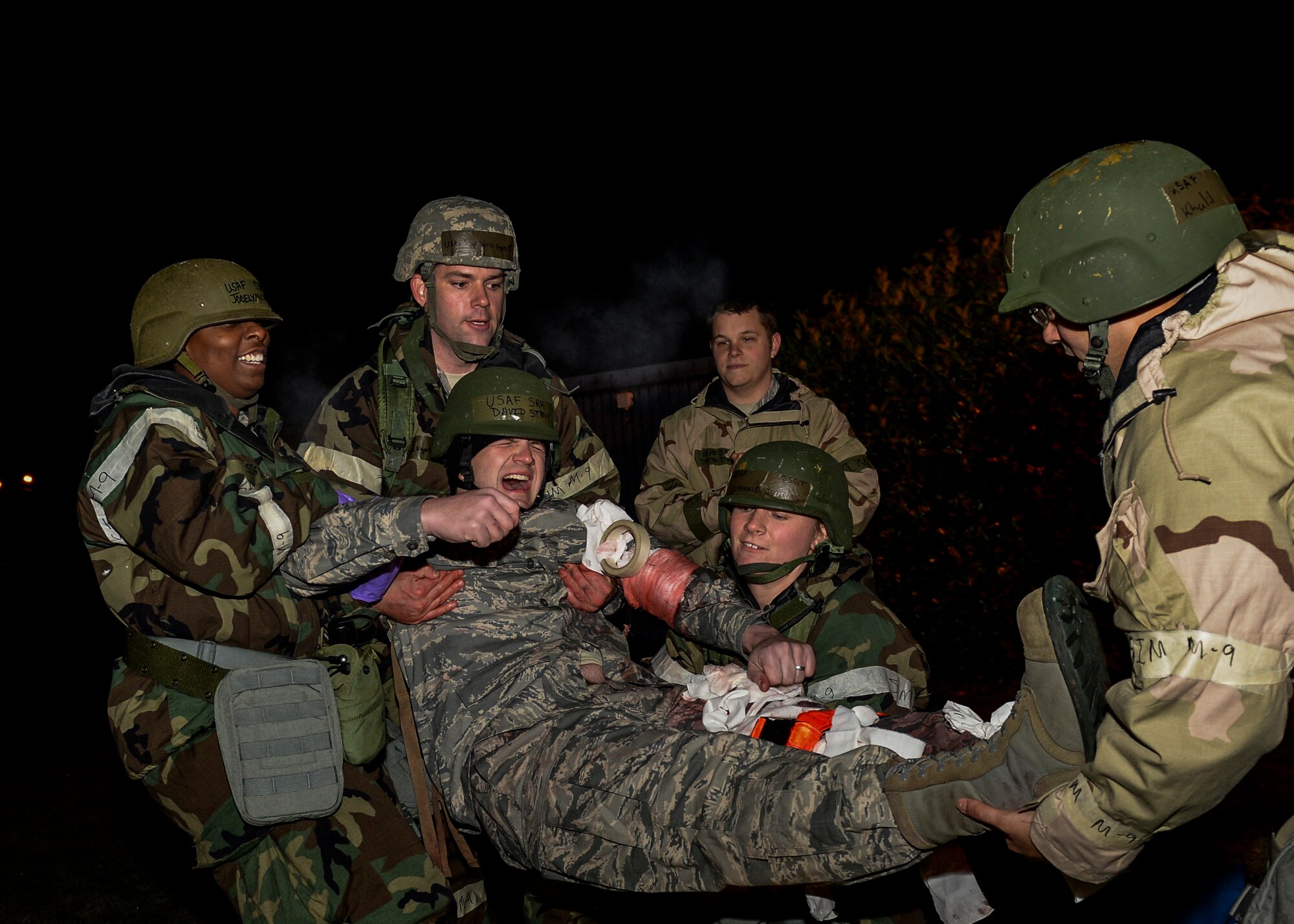 Airmen of the 48th Operations Support Squadron carry a mock victim to safety during a Phase II exercise at Royal Air Force Lakenheath, England, Nov. 20, 2013. Liberty Airmen participated in a series of simulated scenarios to test their readiness. (U.S. Air Force photo by Airman 1st Class Nigel Sandridge/Released)