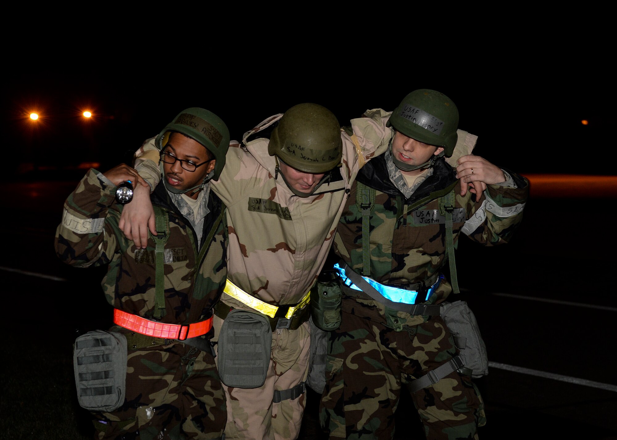 Staff Sgts. Antonio Abney and Justin Henry, 48th Operations Support Squadron aircrew flight equipment technicians, carry a mock victim to safety during a Phase II exercise at Royal Air Force Lakenheath, England, Nov. 20, 2013. Liberty Airmen participated in a series of simulated scenarios to test their readiness. (U.S. Air Force photo by Airman 1st Class Nigel Sandridge/Released)