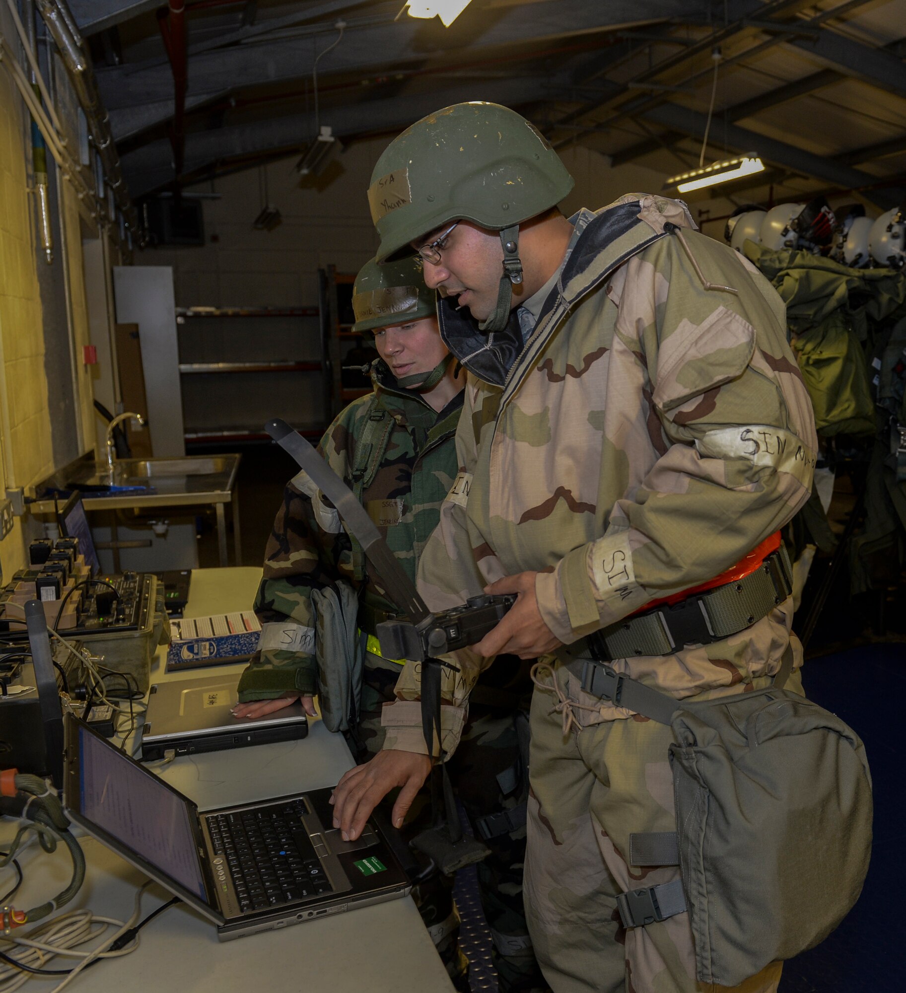 Senior Airman Khalil Yhann and Staff Sgt. Stephanie Jenkins, 48th Operations Support Squadron aircrew flight equipment technicians, inspect a Combat Survivor Evader Locator hand-held radio during a Phase II exercise at Royal Air Force Lakenheath, England, Nov. 20, 2013. Liberty Airmen participated in a series of simulated scenarios to test their readiness. (U.S. Air Force photo by Airman 1st Class Nigel Sandridge/Released)