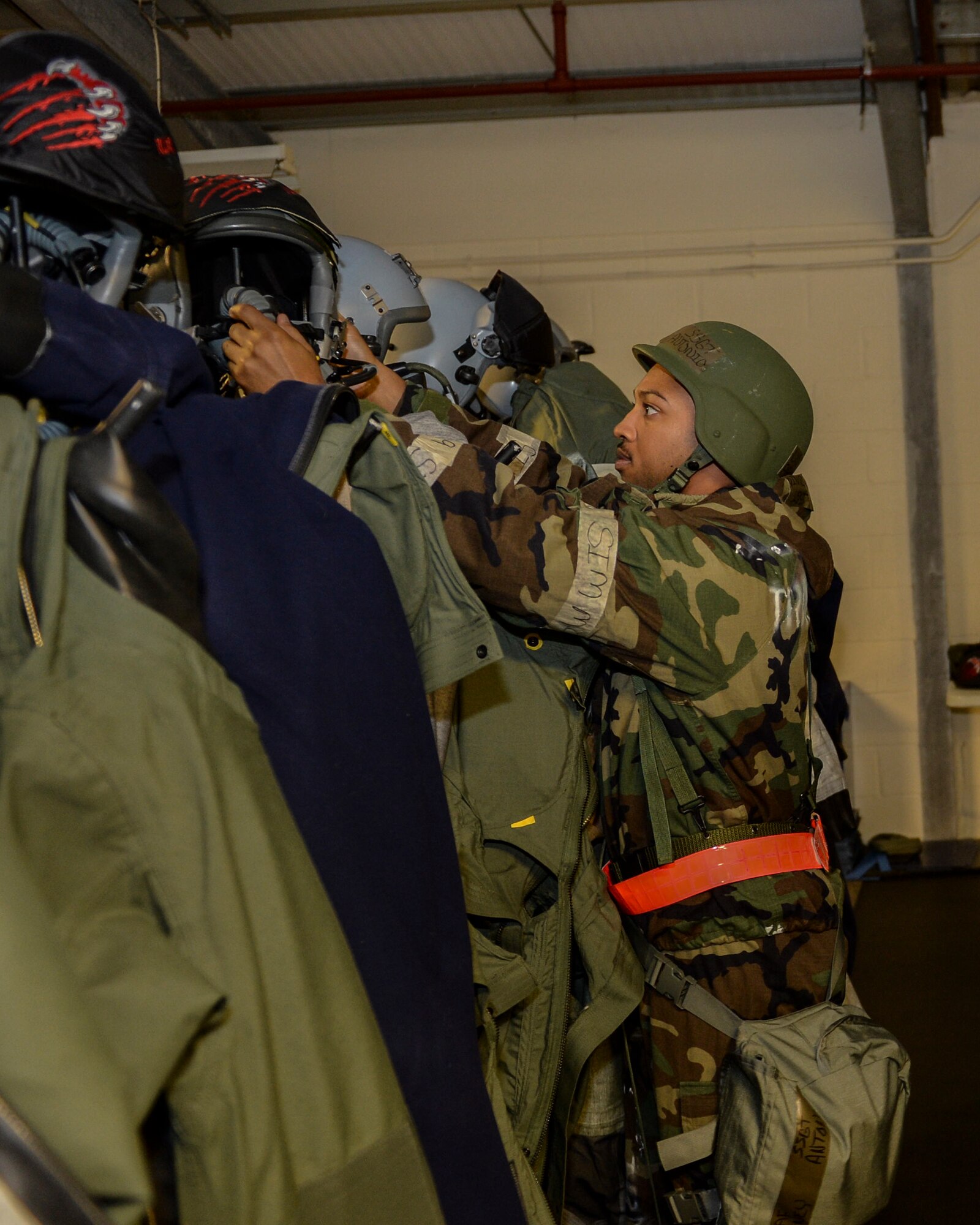 Staff Sgt. Antonio Abney, 48th Operations Support Squadron aircrew flight equipment technician, prepares pilot flight suits during a Phase II exercise at Royal Air Force Lakenheath, England, Nov. 20, 2013. Liberty Airmen participated in a series of simulated scenarios to test their readiness. (U.S. Air Force photo by Airman 1st Class Nigel Sandridge/Released)