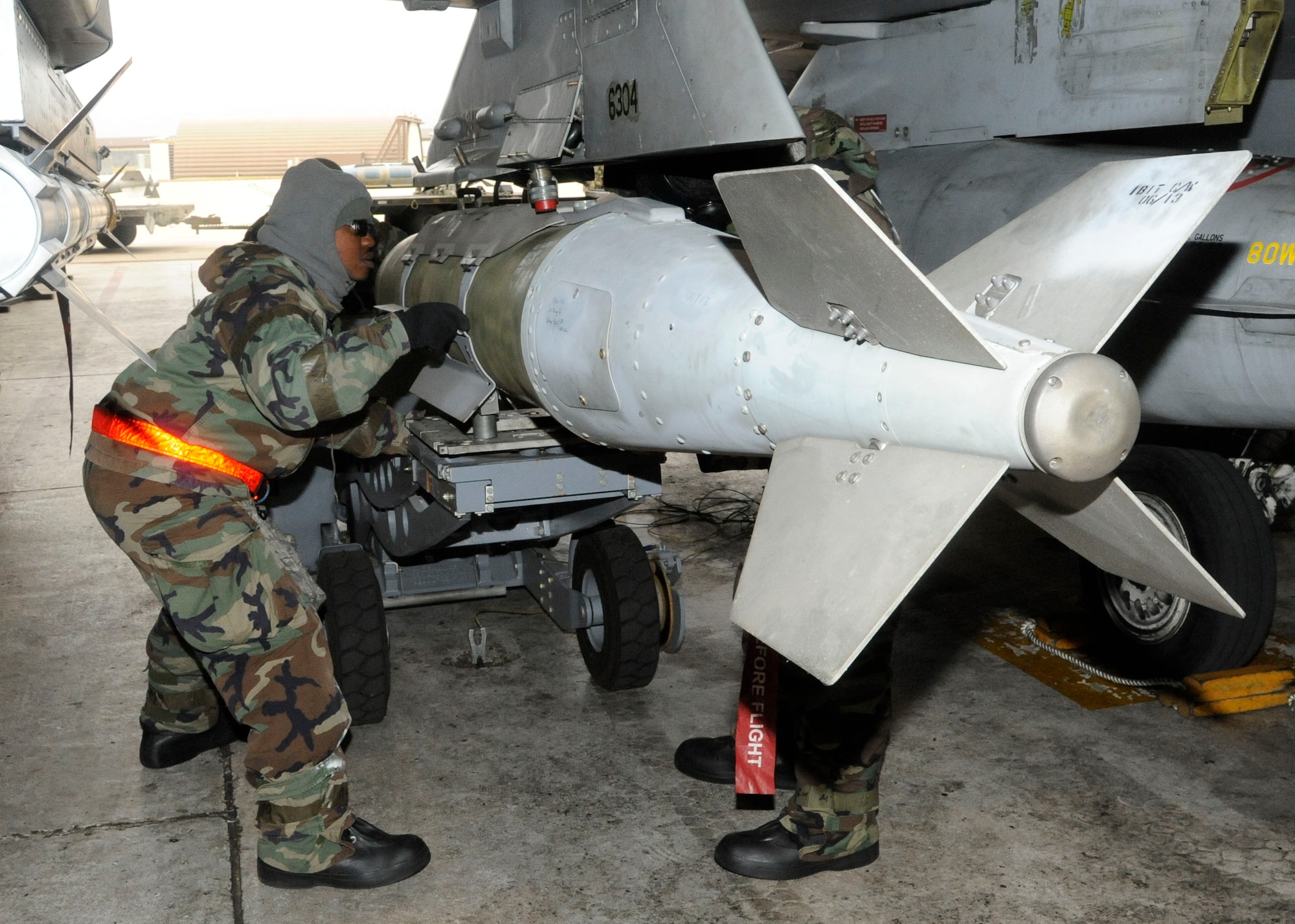 Left to right: Staff Sgts. Jessie Barnett and Marcus Knight, 8th Aircraft Maintenance Squadron, arm an F-16 during exercise Beverly Bulldog 14-01 at Kunsan Air Base, Republic of Korea, Nov. 20, 2013. Exercise Beverly Bulldog 14-01 demonstrates and enhances the readiness of 7th Air Force to defend and sustain the capabilities which strengthen the ROK-U.S. Alliance. (U.S. Air Force photo by Staff Sgt. Jessica Haas/Released)