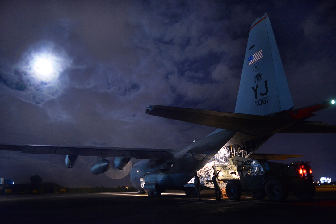 U.S. airmen and Marines load humanitarian relief supplies onto a C-130H aircraft during Operation Damayan at Villamor Air Base, Philippines, Nov. 18, 2013.