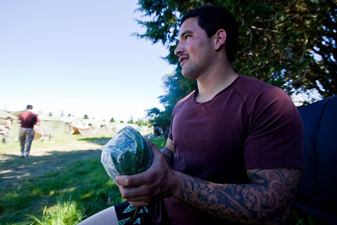 Pvt. Kereti Edwards, signaler with 2 Signal Squadron, from Tauranga, New Zealand makes a rugby ball out of a towel, a plastic bag, grass and tape in the field during exercise Southern Katipo 2013 aboard Timaru, New Zealand, Nov. 16. SK13 allows our service members to collaborate with partner countries to achieve mutual security goals, address shared concerns and continue to enhance our interoperability. 