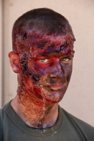 MARINE CORPS BASE CAMP PENDLETON, Calif., -- Lance Cpl. Matthew Fortunas, radio operator, Tango Battery, 5th Battalion, 11th Marine Regiment, and a native of Wichita Falls, Texas, wears makeup to simulate a burnt casualty during a training exercise at the Mobile Immersion Trainer here, Nov. 14, 2013. The MIT is similar to the Infantry Immersion Trainer and trains Marines to operate under stressful conditions. Throughout the morning, the battery simulated operating out of a base and posted security while mock insurgents attempted to breach the area and formed riots. The artillerymen later conducted a logistics patrol and recovered a broken vehicle, countered an improvised explosive device and repelled enemy role-players during an ambush. The battery is slated to continue predeployment training before deploying to Afghanistan this winter.