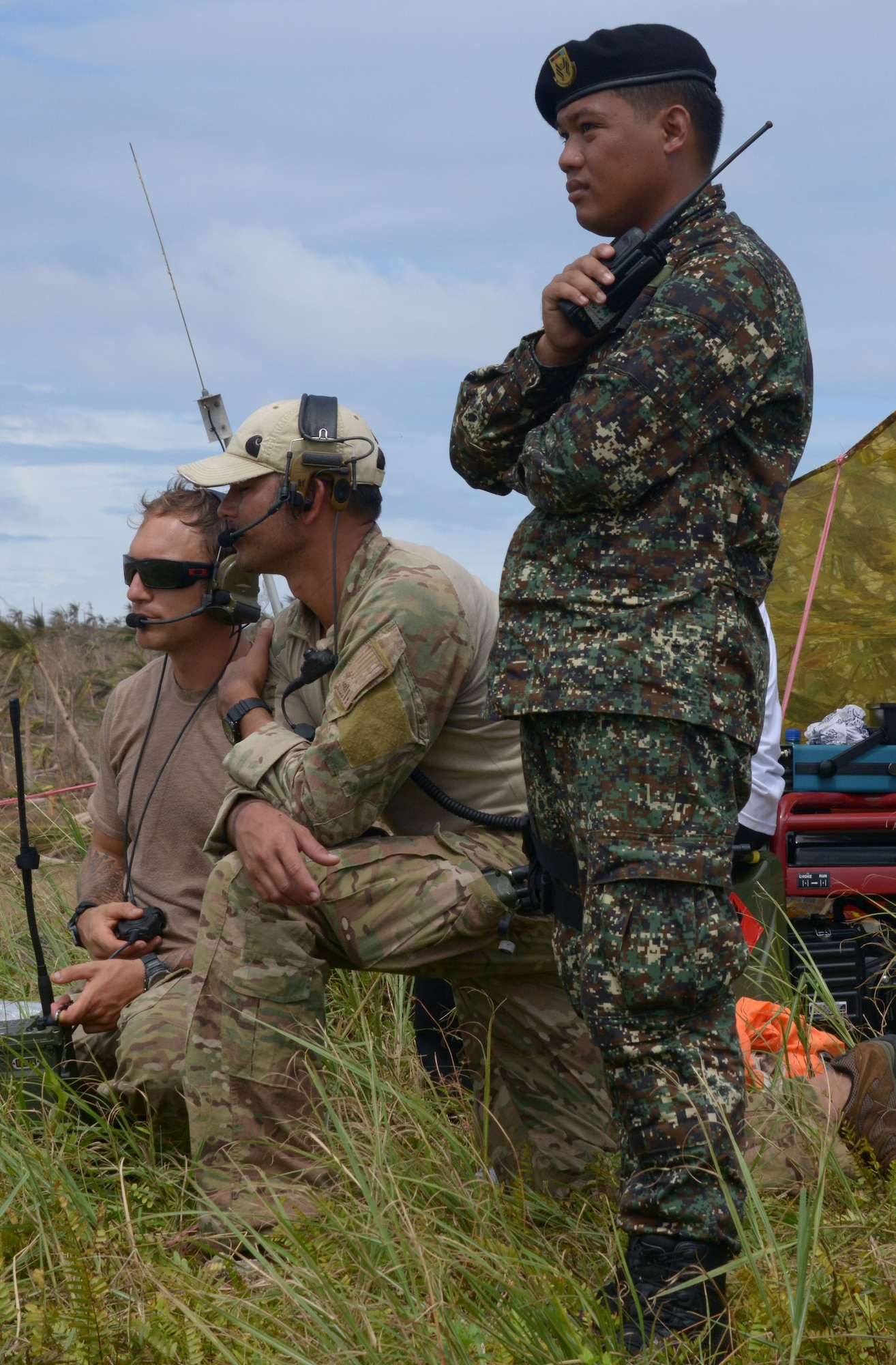 From left, Staff Sgt. Aaron Davis, Master Sgt. Tobin Berry and a member of the Armed Forces of the Philippines, direct air traffic Nov. 17, 2013, at Guiuan Airport, Republic of the Philippines. The special tactics Airmen, deployed from Kadena Air Base, Japan, worked with the Philippine military in support of Operation Damayan to open the airfield in the aftermath of Typhoon Haiyan. Davis and Barry are combat controllers with the 353rd Special Operations Group. (U.S. Air Force photo by Tech. Sgt. Kristine Dreyer) 