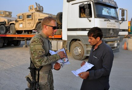 Sgt. Anthony R. Stenson, with the 1157th Transportation Company, goes over paperwork with an Afghan truck driver at Jalalabad Airfield, Afghanistan, Aug. 24. One of the main tasks for Soldiers of the unit is providing convoy security and that starts with making checks and inspections prior to heading out on a mission.