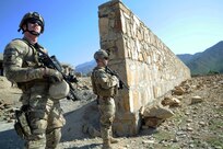 Spc. Andrew Simmons, and Army Sgt. Adam Priebe, both assigned to Company A, 1st Battalion, 143rd Infantry Regiment (Airborne), provide security outside the Shigal Girl's School in Kunar Province, Afghanistan while members of Provincial Reconstruction Team Kunar visit the school to check on the status of construction. The members of Company A serve as the PRT's security element and have earned high praise from the PRT commander.