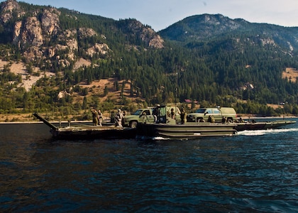 Combat engineers from the Canadian Army and the Washington Army National Guard transport two Canadian military police vehicles up the Columbia River here using bridge boat pontoons Aug. 20 as part of training exercise Kootenay Castor 2012. The vehicles are being relocated to support the main training event of the exercise.