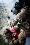 Spc. Terry Mills, with Company F, 1st Battalion, 171st Aviation Regiment, pulls Army Staff Sgt. Ryan Stumpff into a UH-60 Black Hawk helicopter in Khowst Province, Afghanistan. Stumpff was stranded on a narrow cliff after being wounded in an ambush. Mills, who served as an aviation crew chief in the Army in the 1980s, retired as a civilian firefighter four years ago and enlisted in the Mississippi Army National Guard.