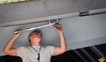 Senior Airman William Fine, an aircraft phase maintenance specialist with the 455th Expeditionary Maintenance Squadron, works on the wing of an A-10 Thunderbolt II aircraft during phase maintenance at Bagram Air Field, Afghanistan.