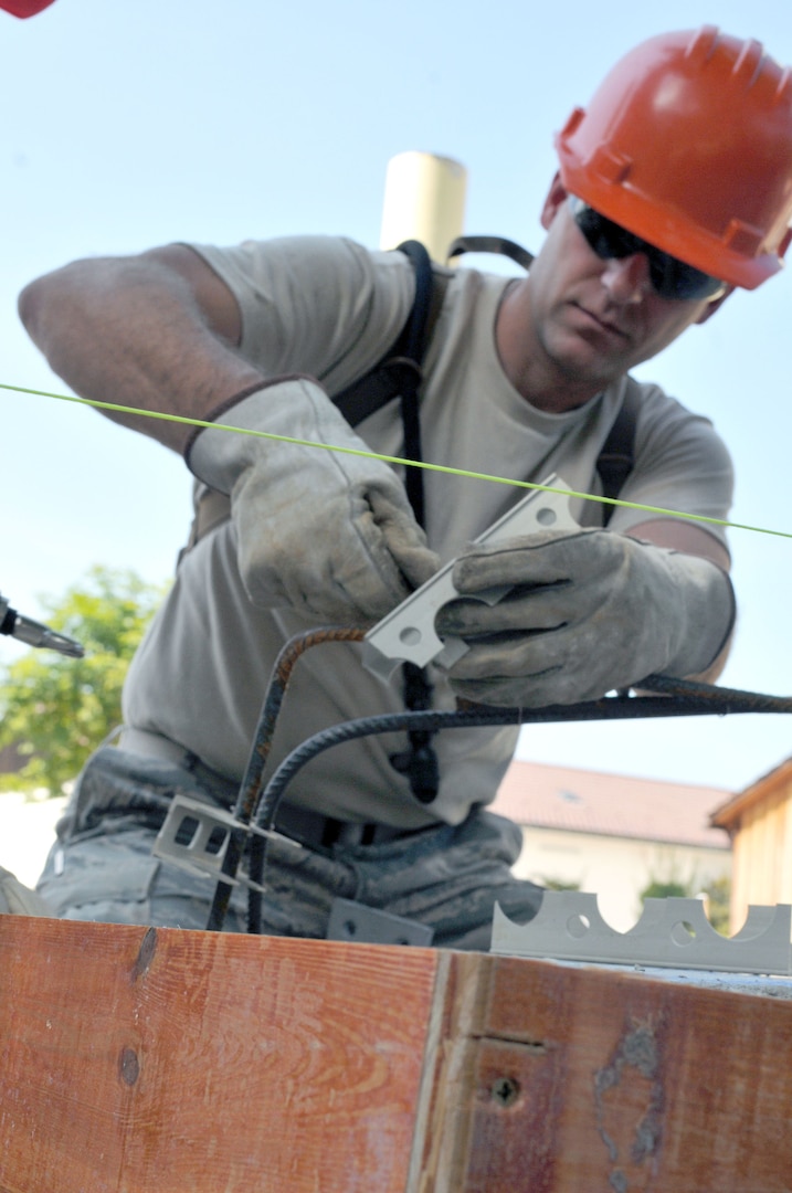 Airman 1st Class Jeremiah Voyles, with the Wyoming Air National Guard's 153rd Civil Engineer Squadron, prepares to put rebar in place Aug. 13, 2012 while working on a construction project at the NATO School in Oberammergau, Germany. The rebar provides strength to the concrete poured. Airmen from the 153rd CES are putting their skills to work as they work on various construction projects throughout the school grounds.