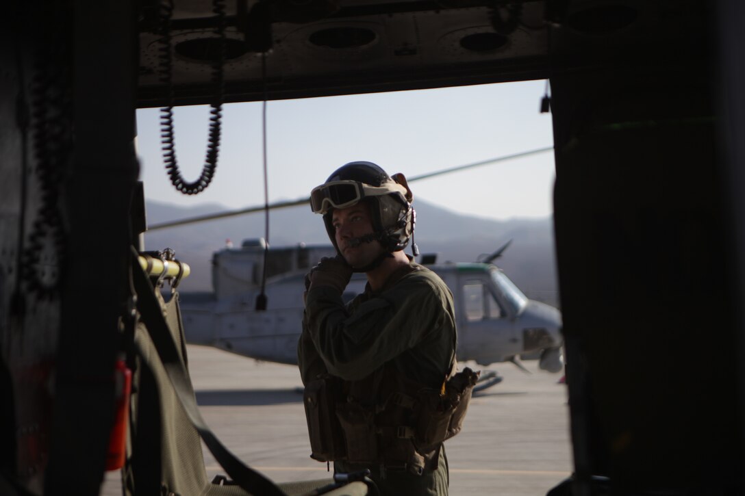 Lance Cpl. Trevor Cannefax of Light Attack Helicopter Squadron 773 secures his helmet strap before a flight, Nov. 15, 2013, in support of exercise Raven 14-01 here. Exercise Raven is an aviation training exercise designed to provide air support to Marine Corps Forces Special Operations Command to better prepare them for their upcoming deployment. (Official photo by Lance Cpl. Brytani Musick)