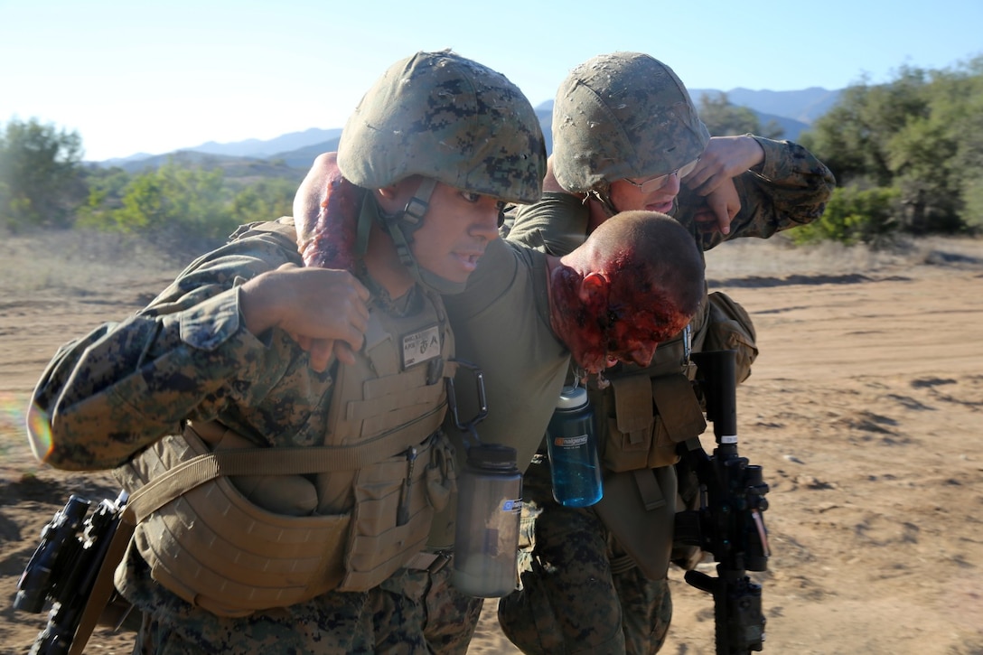 MARINE CORPS BASE CAMP PENDLETON, Calif., -- Marines with Tango Battery, 5th Battalion, 11th Marine Regiment, carry a simulated burnt casualty to a safety vehicle during a training exercise at the Mobile Immersion Trainer here, Nov. 14, 2013. The MIT is similar to the Infantry Immersion Trainer and trains Marines to operate under stressful conditions. Throughout the morning, the battery simulated operating out of a base and posted security while mock insurgents attempted to breach the area and formed riots. The artillerymen later conducted a logistics patrol and recovered a broken vehicle, countered an improvised explosive device and repelled enemy role-players during an ambush.