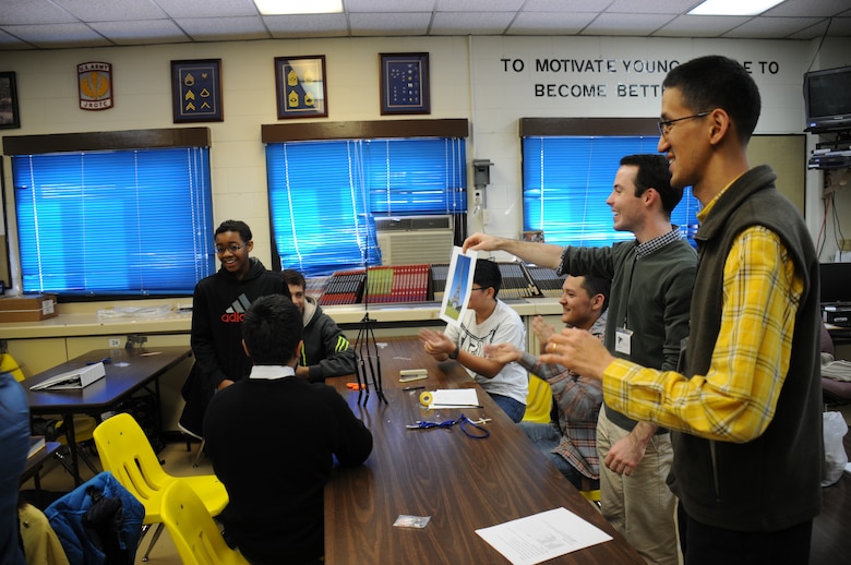 Far East District civil engineer C.J. Lee (right) and Department of the Army engineer intern Will Sheehan instruct Junior Reserve Officers' Training Corps cadets at Seoul American High School. Far East District engineers spent the morning of Nov. 21 and Nov. 22 explaining how engineers affect our lives and it impact our world. The presentation's aim was to broaden the students' perspectives and sparked their interests in engineer career fields.