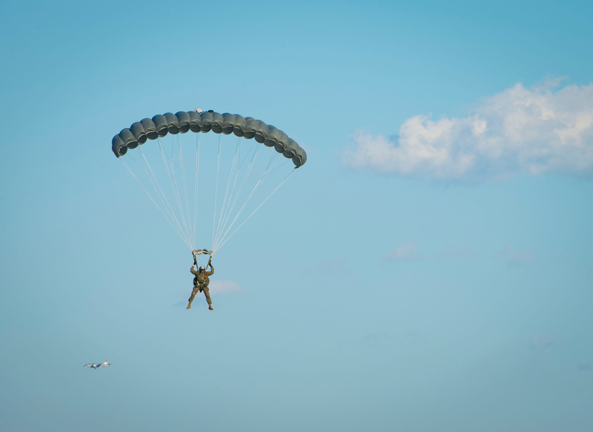 A Marine with the 3rd Marine Division, 3rd Reconnaissance Battalion, parachutes to the ground after jumping from a C-130 Hercules over Yokota Air Base, Japan, Nov. 19, 2013. The Marines perform these jumps quarterly to maintain the necessary qualifications. (U.S. Air Force photo by Staff Sgt. Chad C. Strohmeyer/Released)