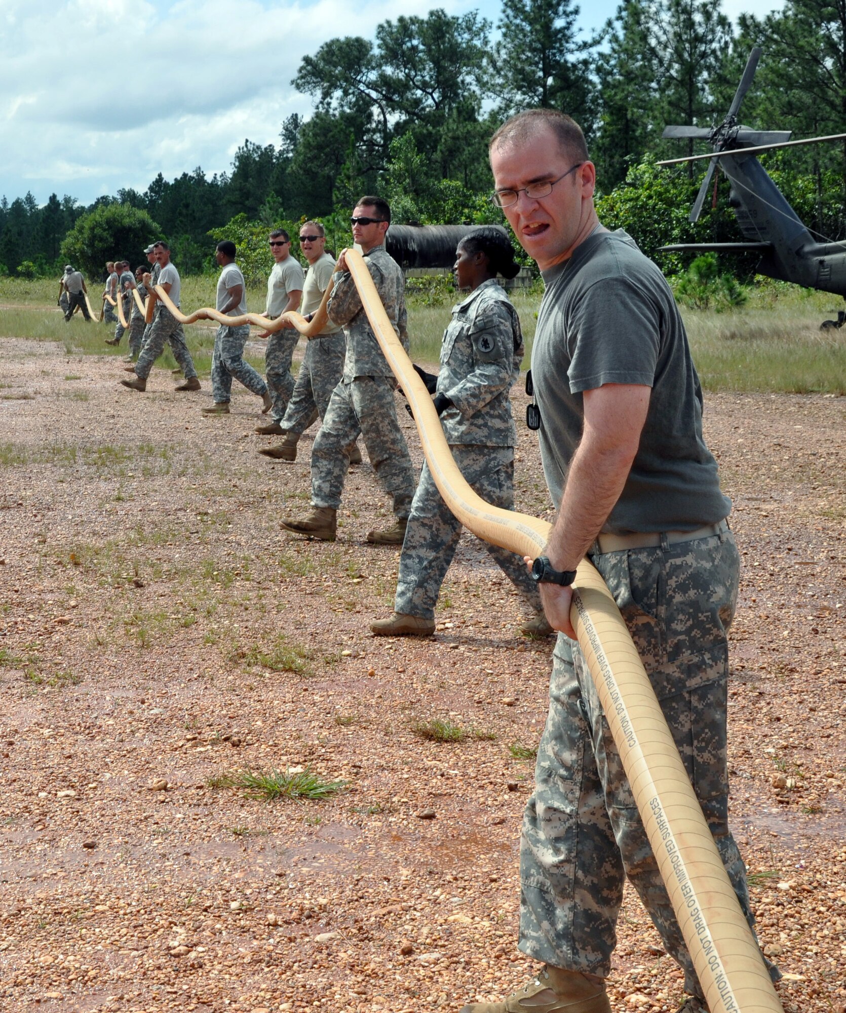 Members of the 1-228th Aviation Regiment work together to move a fuel line in order to refuel a CH-47 Chinook helicopter at Mocoron, Honduras, Nov. 20, 2013.  The 1-228th spent a week at the remote location of Mocoron as part of a Collective Training Exercise (CTE), during which the members of the unit lived in a field environment while executing both training as well as real-world missions.  (U.S. Air Force photo by Capt. Zach Anderson)