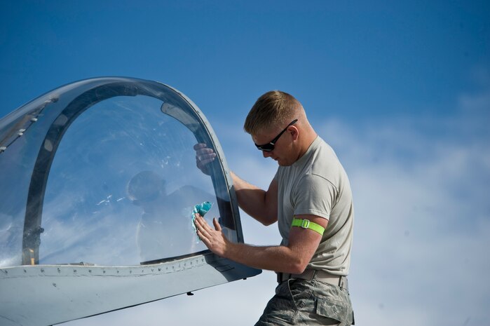 U.S. Air Force Airman 1st Class Adam Fingleman, 757th Aircraft Maintenance Squadron crew chief, cleans the canopy of an A-10 Thunderbolt II Nov. 18, 2013, at Nellis Air Force Base, Nev. The A-10 Thunderbolt II’s airframe was designed for survivability.  It is composed of 1,200 pounds of armor for protection of the cockpit and aircraft systems that enables the aircraft to continue flying after taking significant damage. (U.S. Air Force photo by Airman 1st Class Jason Couillard)