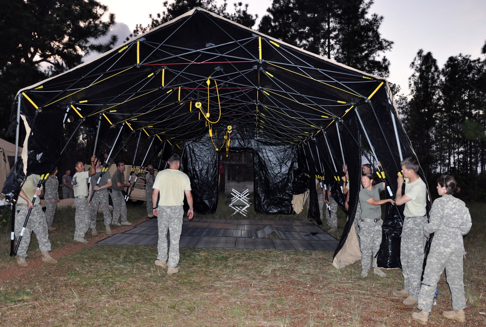 Members of the 1-228th Aviation Regiment work together to set up a sleeping tent at Mocoron, Honduras as part of a week-long Collective Training Exercise (CTE) being conducted by the unit, Nov. 17, 2013.  During the exercise, the members of the 1-228th operated from a field environment and responded to both exercise and real-world mission requirements.  (U.S. Air Force photo by Capt. Zach Anderson)