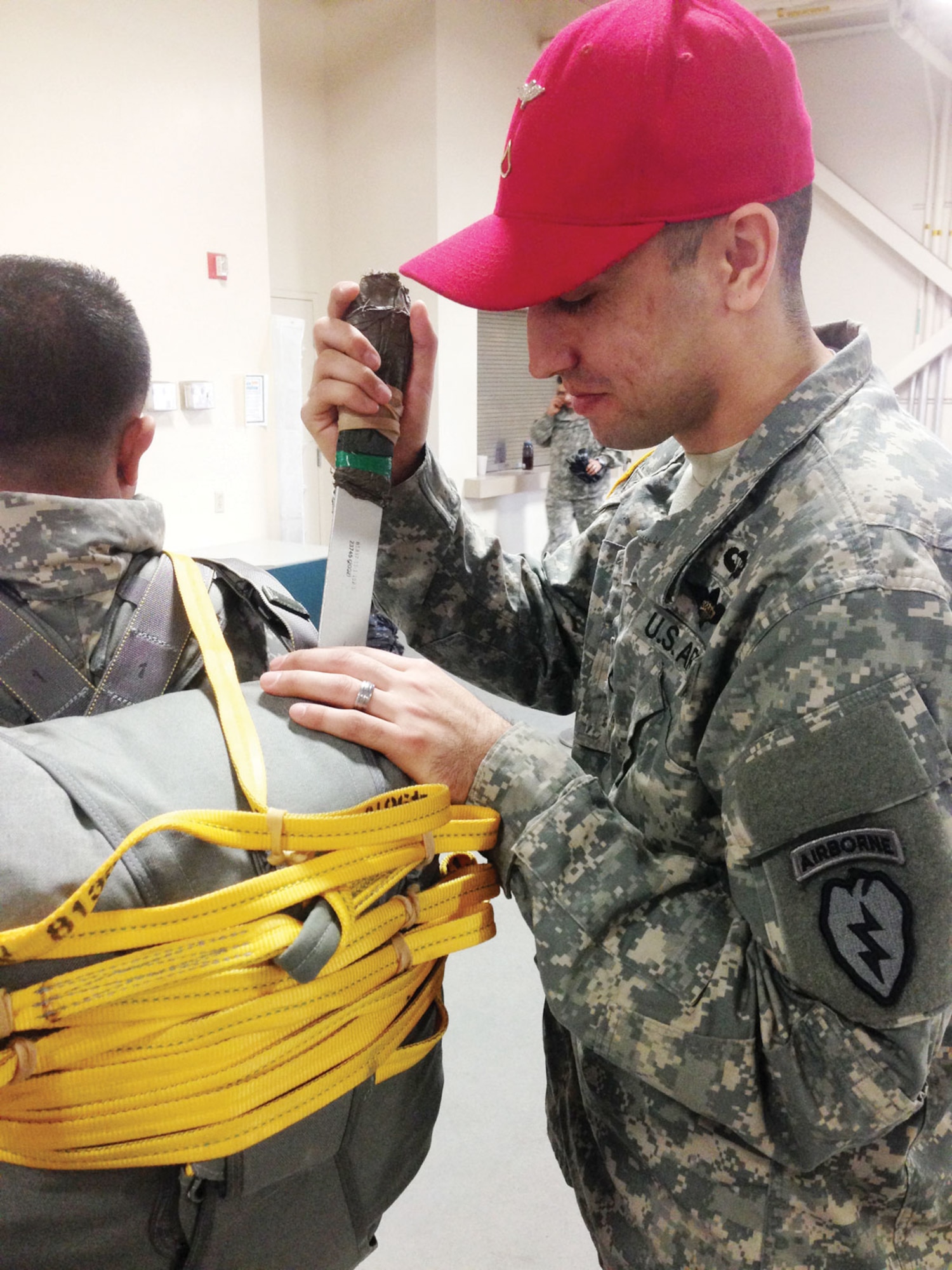 Pfc. Thomas Perez, a rigger with the 725th Brigade Support Battalion, 4th Infantry Brigade Combat Team (Airborne), 25th Infantry Division, and a native of Elizabeth, N.J., tightens a Soldier’s parachute pack at the Joint Military Complex Nov. 5 for an airdrop training mission. (U.S. Army photo/Staff Sgt. Eric-James Estrada)