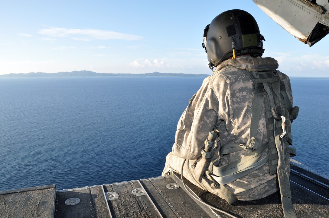 A crewchief takes in the view from the ramp of a CH-47 Chinook helicopter assigned to the 1-228th Aviation Regiment as it flies off the coast of Honduras, Nov. 19, 2013.  The helicopter crew was participating a training scenario as part of a week-long Collective Training Exercise (CTE) being condcuted by the 1-228th.  (U.S. Air Force photo by Capt. Zach Anderson)