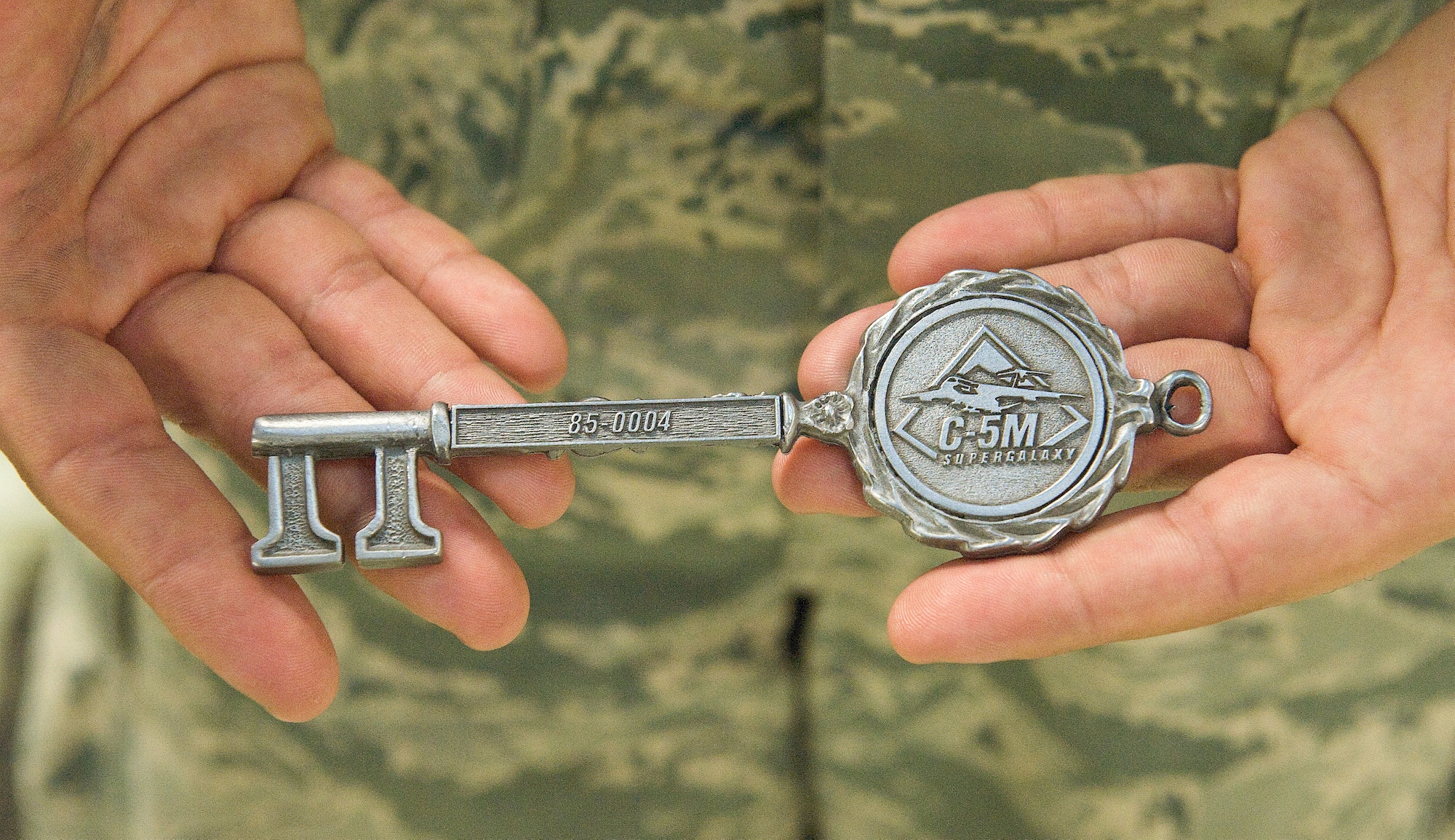 Staff Sgt. Justin Rojas, 436th Aircraft Maintenance Squadron dedicated crew chief, holds the ceremonial aircraft key to C-5M 85-0004 Nov. 21, 2013, at Dover Air Force Base, Del. Team Dover received its 13th C-5M Super Galaxy out of 18. (U.S. Air Force photo/Roland Balik)