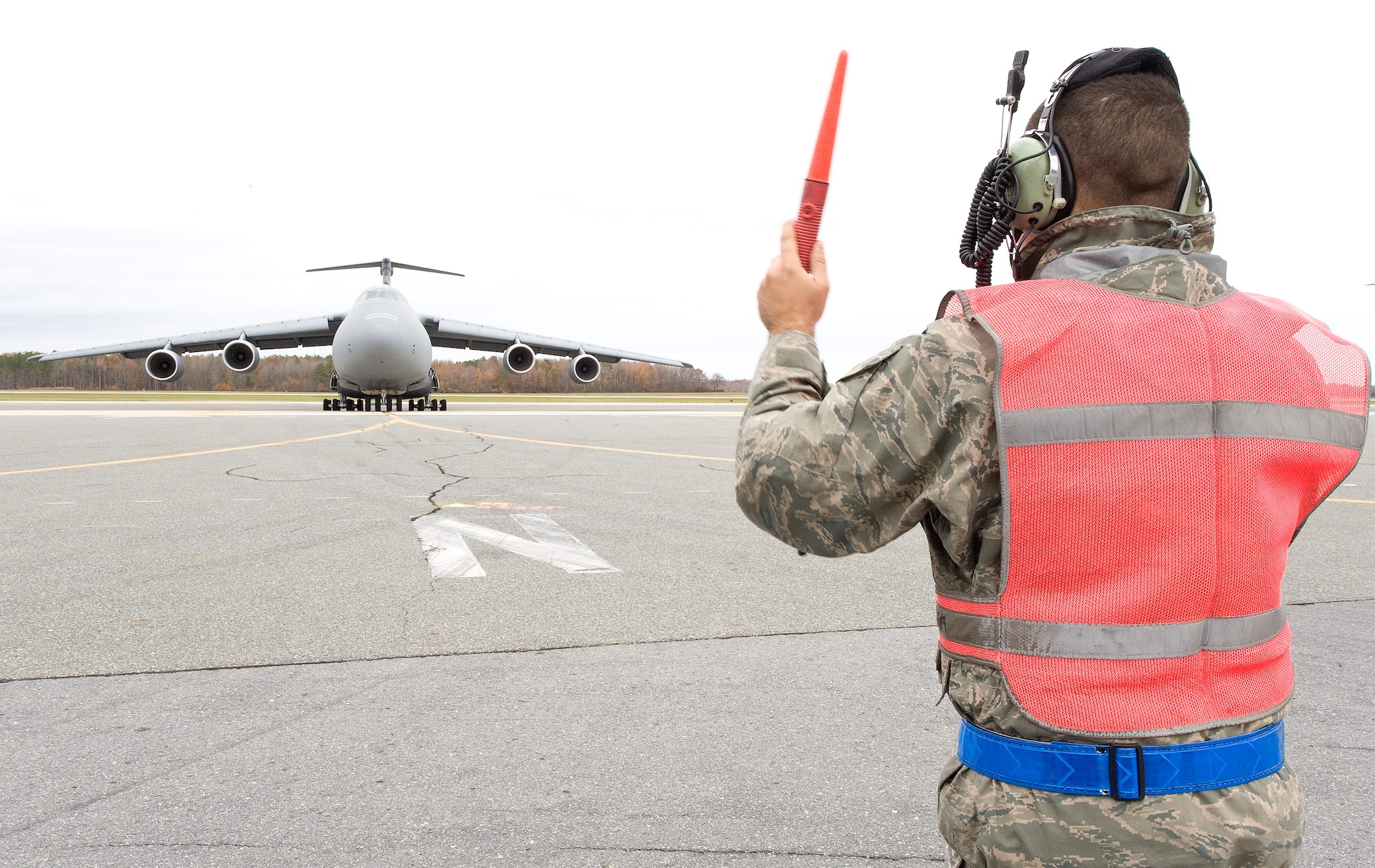 Staff Sgt. Justin Rojas, 436th Aircraft Maintenance Squadron dedicated crew chief, marshals a C-5M Super Galaxy onto its parking spot Nov. 21, 2013, at Dover Air Force Base, Del. Tail number 85-0004 is the 13th C-5M to be delivered to Dover AFB. (U.S. Air Force photo/Roland Balik)
