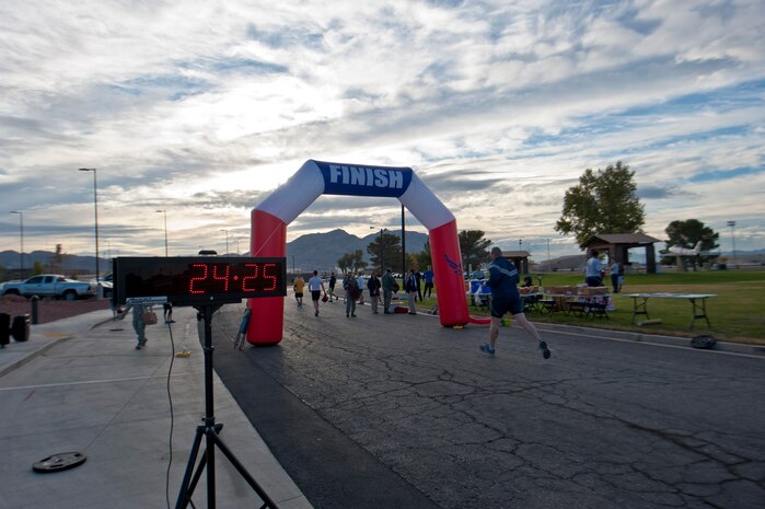 An Airman from Nellis Air Force Base runs toward the finish line at the 5k Turkey Trot/Great American Smokeout in front of the Warrior Fitness Center, Nov. 21, 2013, at Nellis Air Force Base, Nev. After the run, race participants participated in a drawing in which the winners received a Turkey to roast for the upcoming Thanksgiving holiday. (U.S. Air Force photo by Airman 1st Class Thomas Spangler)  