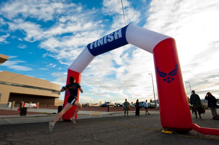 Airman 1st Class Alesha Beverly, 99th Medical Support Squadron patient administrator, sprints toward the finish line at the 5k Turkey Trot/Great American Smokeout in front of the Warrior Fitness Center, Nov. 21, 2013, at Nellis Air Force Base, Nev. The top three finishers in the race for both males and females received plaques for their performance. (U.S. Air Force photo by Airman 1st Class Thomas Spangler)