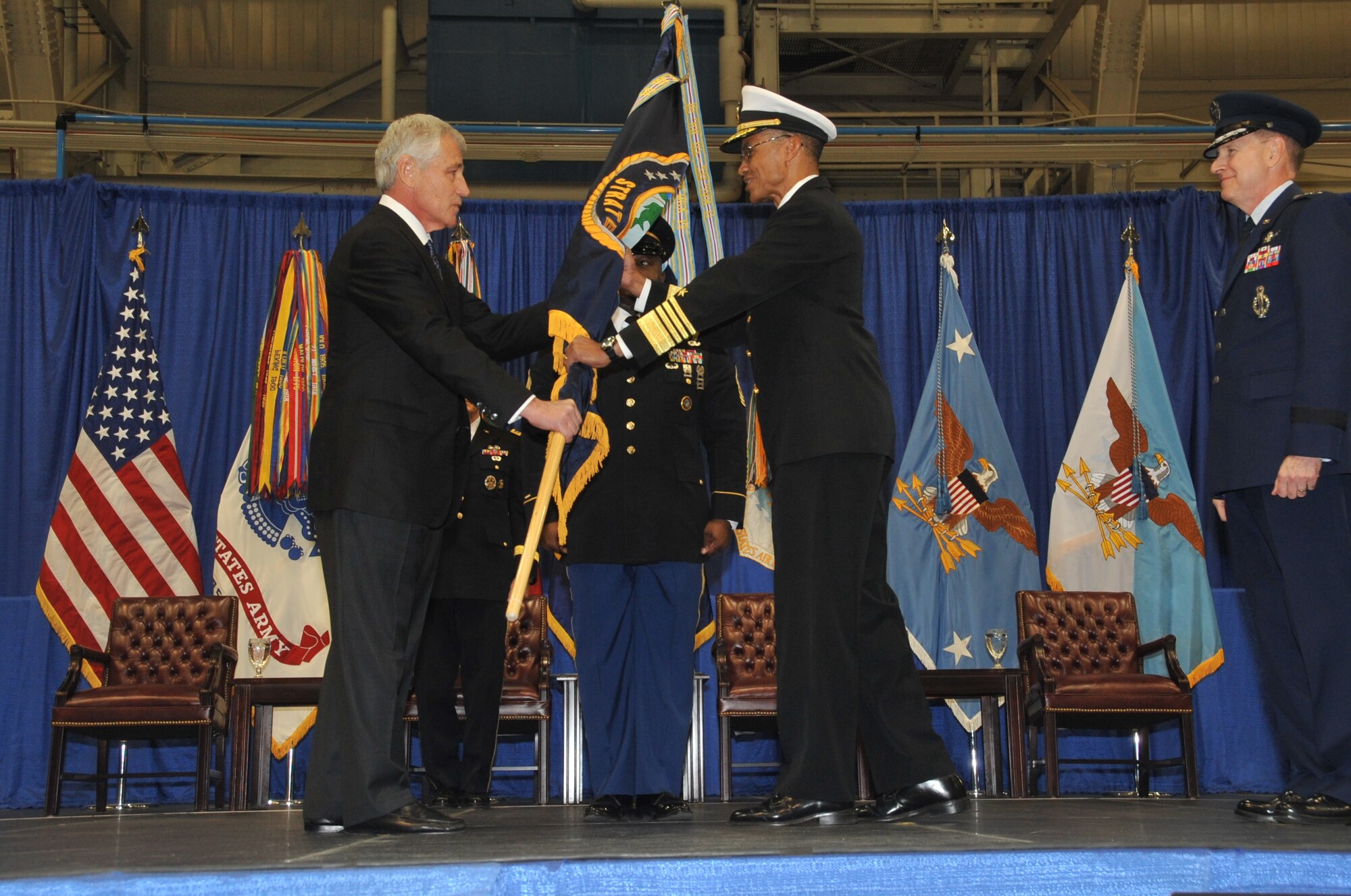 U.S. Navy Adm. Cecil Haney accepts the U.S. Strategic Command colors from Secretary of Defense Chuck Hagel, as outgoing commander U.S. Air Force Gen. C. Robert Kehler looks on, during the U.S. Strategic Command change of command ceremony at Offutt Air Force Base, Neb., Nov. 15. (U.S. Air Force photo by Steve Cunningham/Released)