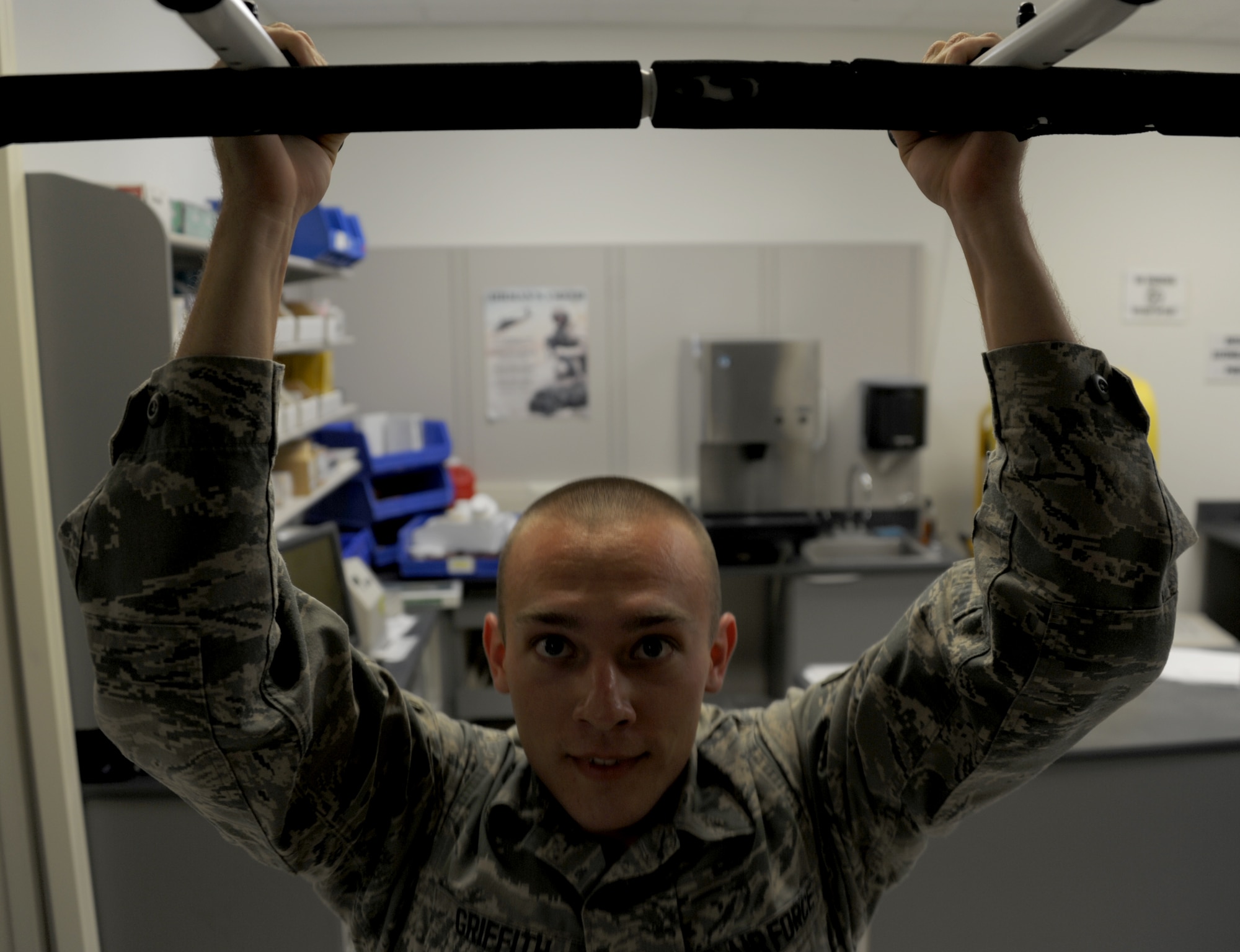 Senior Airman Ryan Griffith does a set of pull-ups on Maxwell Air Force Base, Nov. 6. Every hour, the 42nd Medical Group’s pharmacy flight gathers in a back room and does sets of pushups, sit-ups or pull-ups. (U.S. Air Force photo by Staff Sgt. Natasha Stannard)