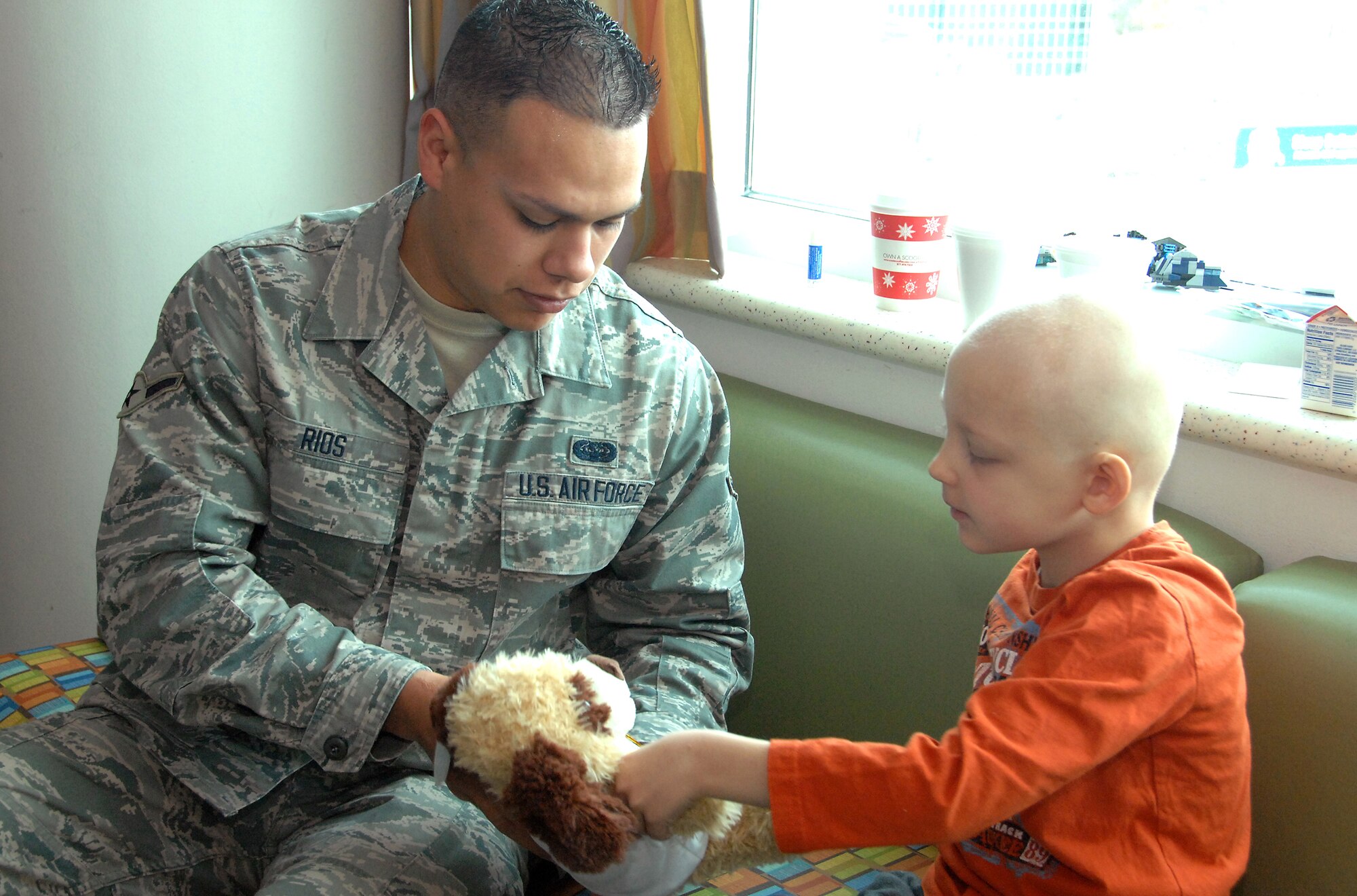 Airman Evan Rios, a 55th Strategic Communications Squadron communications operator from Offutt AFB, NE, visits with Jack Moldovan, 7, during a visit to Omaha’s Children’s Hospital and Medical Center in Omaha, NE Nov. 20. Rios was part of a group of Offutt volunteers who delivered over 90 stuffed animals on behalf of the Air Force Sergeants Association, Chapter 984. The special Noah’s Ark Workshop animals included 64 monkeys, puppy dogs, bears and cows that were assembled by Offutt members. These animals included an internal pouch where patients could place a star after making a wish. All of the animals were made available through donations to Chapter 984 of the AFSA. (U.S. Air Force photo by Delanie Stafford/Released)