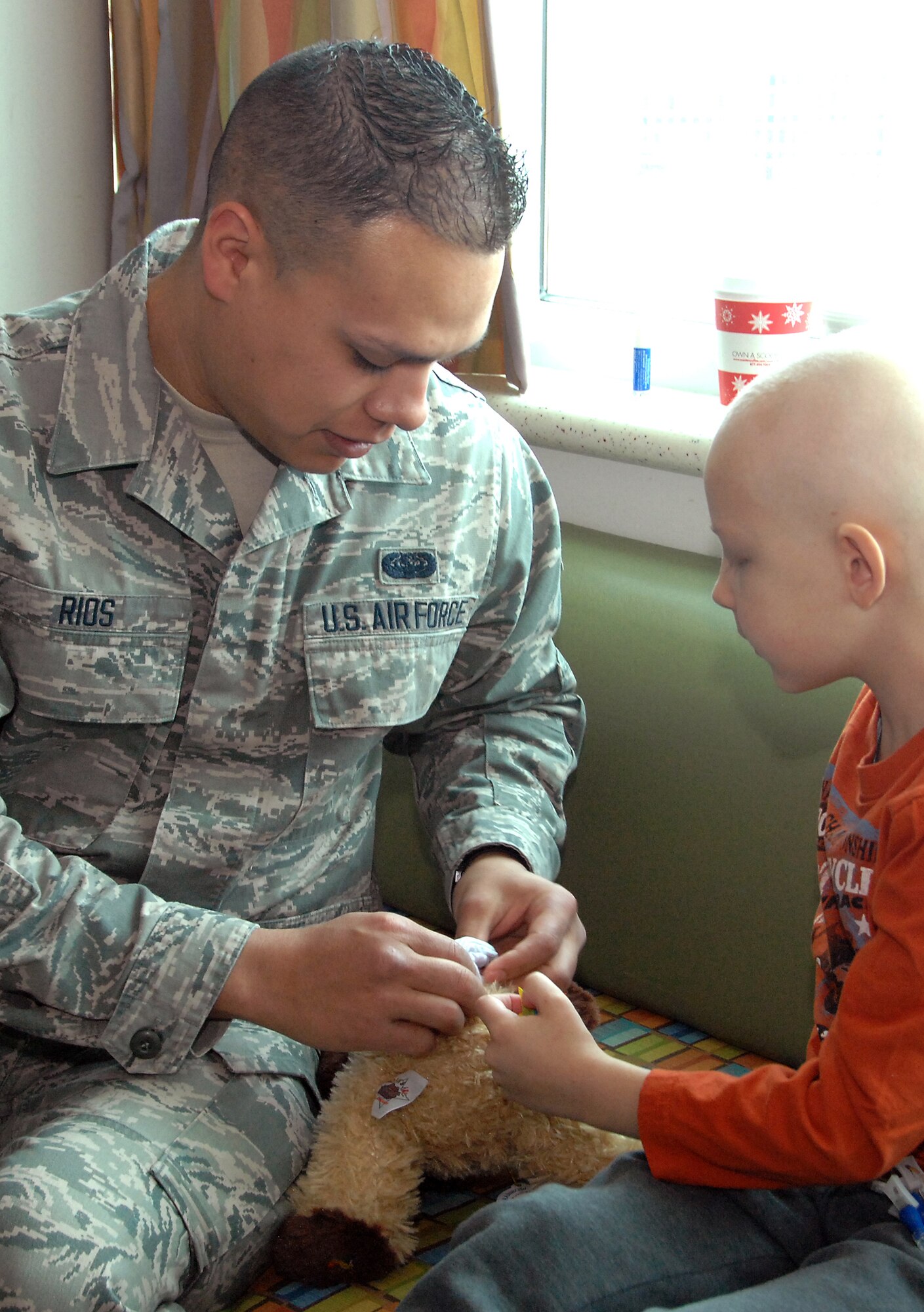 Airman Evan Rios, a 55th Strategic Communications Squadron communications operator from Offutt AFB, helps Jack Moldovan, 7, place his wish star inside a stuffed bear at Omaha’s Children’s Hospital and Medical Center Nov. 20. Airman Rios was part of a group of Offutt volunteers who delivered over 90 stuffed animals on behalf of the Air Force Sergeants Association, Chapter 984. The special Noah’s Ark Workshop animals included 64 monkeys, puppy dogs, bears and cows that were assembled by Offutt members. These animals included an internal pouch where patients could place a star after making a wish. All of the animals were made available through donations to Chapter 984 of the AFSA. (U.S. Air Force photo by Delanie Stafford/Released)