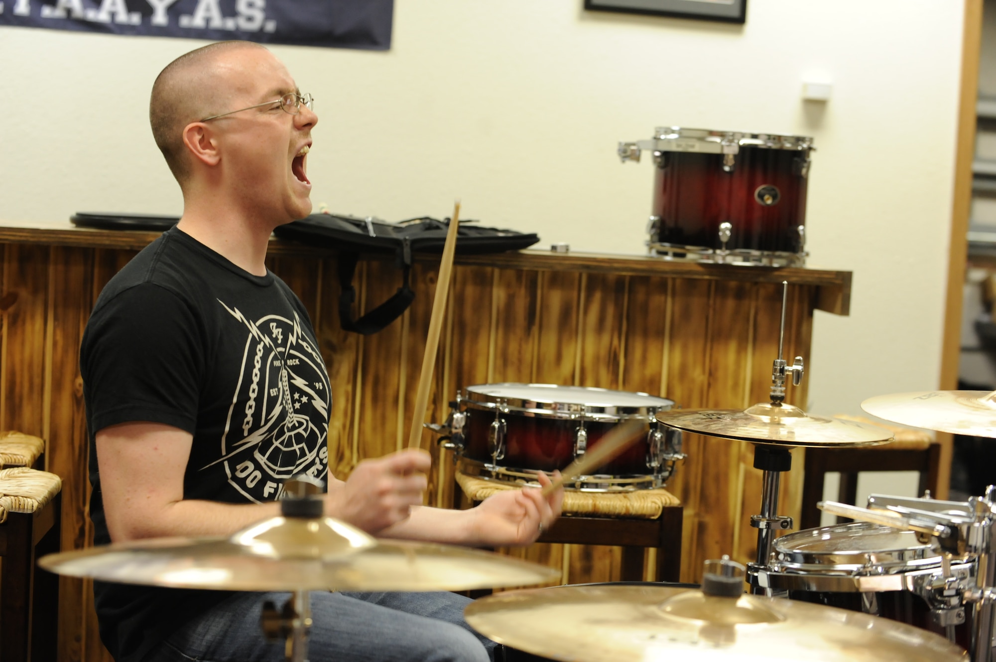 Airman 1st Class Benjamin Haun, 5th Aircraft Maintenance Squadron weapons team member, cheers on his band mates during practice at Minot Air Force Base, N.D., Nov. 9. Haun has served as the drummer for the band RedBall since May 2012 and is currently acting as the band leader and main point of contact for events and performances. (U.S. Air Force photo/Senior Airman Stephanie Sauberan)