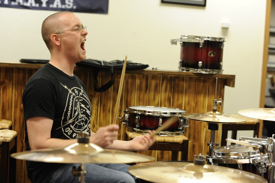 Airman 1st Class Benjamin Haun, 5th Aircraft Maintenance Squadron weapons team member, cheers on his band mates during practice at Minot Air Force Base, N.D., Nov. 9. Haun has served as the drummer for the band RedBall since May 2012 and is currently acting as the band leader and main point of contact for events and performances. (U.S. Air Force photo/Senior Airman Stephanie Sauberan)