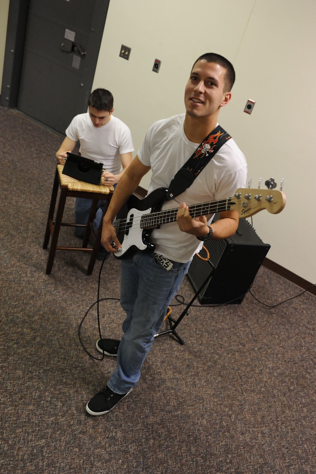 Staff Sgt. Ian Hyzer, 5th Aircraft Maintenance Squadron weapons team chief, tunes his bass guitar as Senior Airman John Hoekstre, 5th Munitions Squadron custody account manager, checks tabs during band practice at Minot Air Force Base, N.D., Nov. 9. Hyzer and Hoekstre both play bass guitar for the band RedBall and have been performing with the group at various base functions for two months and one year respectively. (U.S. Air Force photo/Senior Airman Stephanie Sauberan)