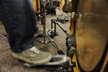 The drummer for RedBall quickly strikes his drum kit using dual peddles during band practice at Minot Air Force Base, N.D., Nov. 9. The band began as a way for its members to raise the morale of their fellow Airmen by combining their musical talents and performing at a variety of base functions. (U.S. Air Force photo/Senior Airman Stephanie Sauberan)