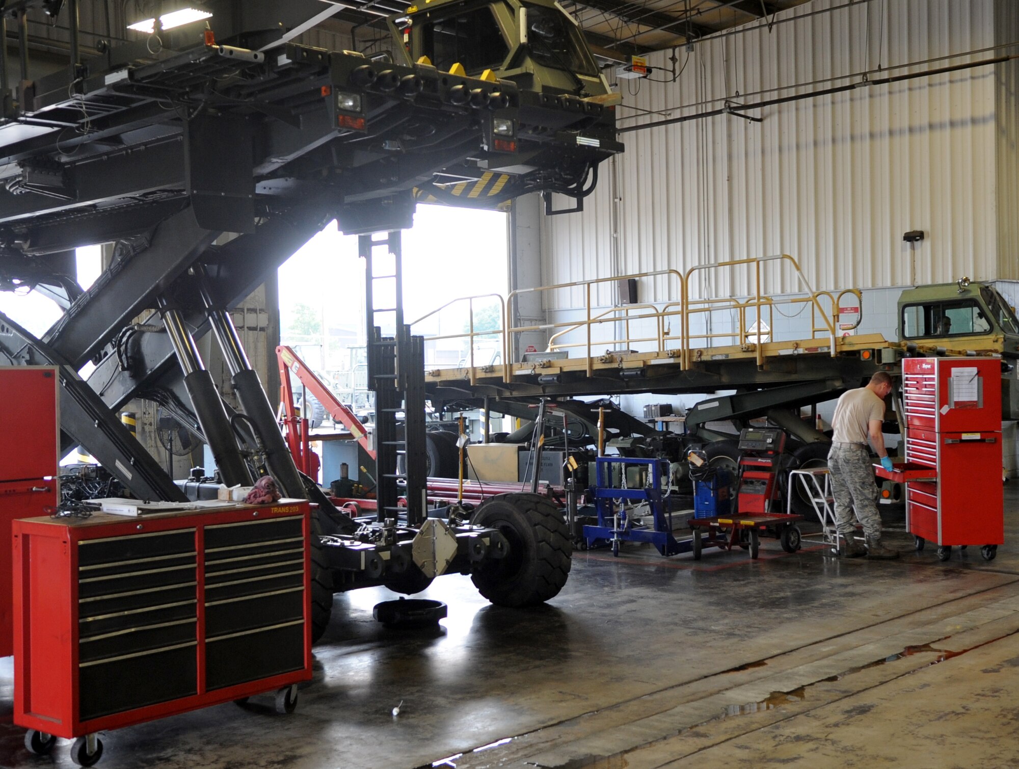 Airman 1st Class Eric Poole, a 19th Logistics Readiness Squadron vehicle equipment maintenance journeyman, gets a tool to perform maintenance on a aircraft cargo loader Sept. 11, 2013, at Little Rock Air Force Base, Ark. The 463L maintenance shop maintains cargo loaders forklifts, and adverse terrain equipment for the base. (U.S. Air Force photo by Staff Sgt. Caleb Pierce) 