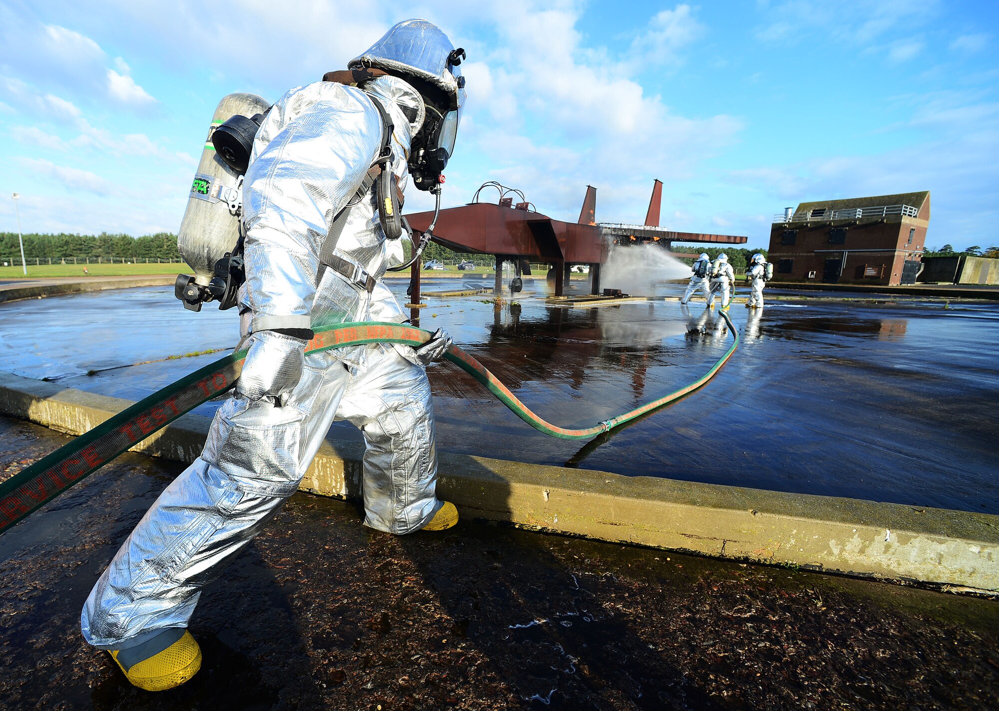 Firefighters of the 48th Civil Engineer Squadron extinguish a mock F-15 aircraft at the fire training pit at Royal Air Force Lakenheath, England, Nov. 21, 2013. One aspect of the Phase II was testing the deployed response capabilities of Airmen through various scenarios to ensure mission readiness.  (U.S. Air Force photo by Senior Airman Tiffany M. Grigg/Released)