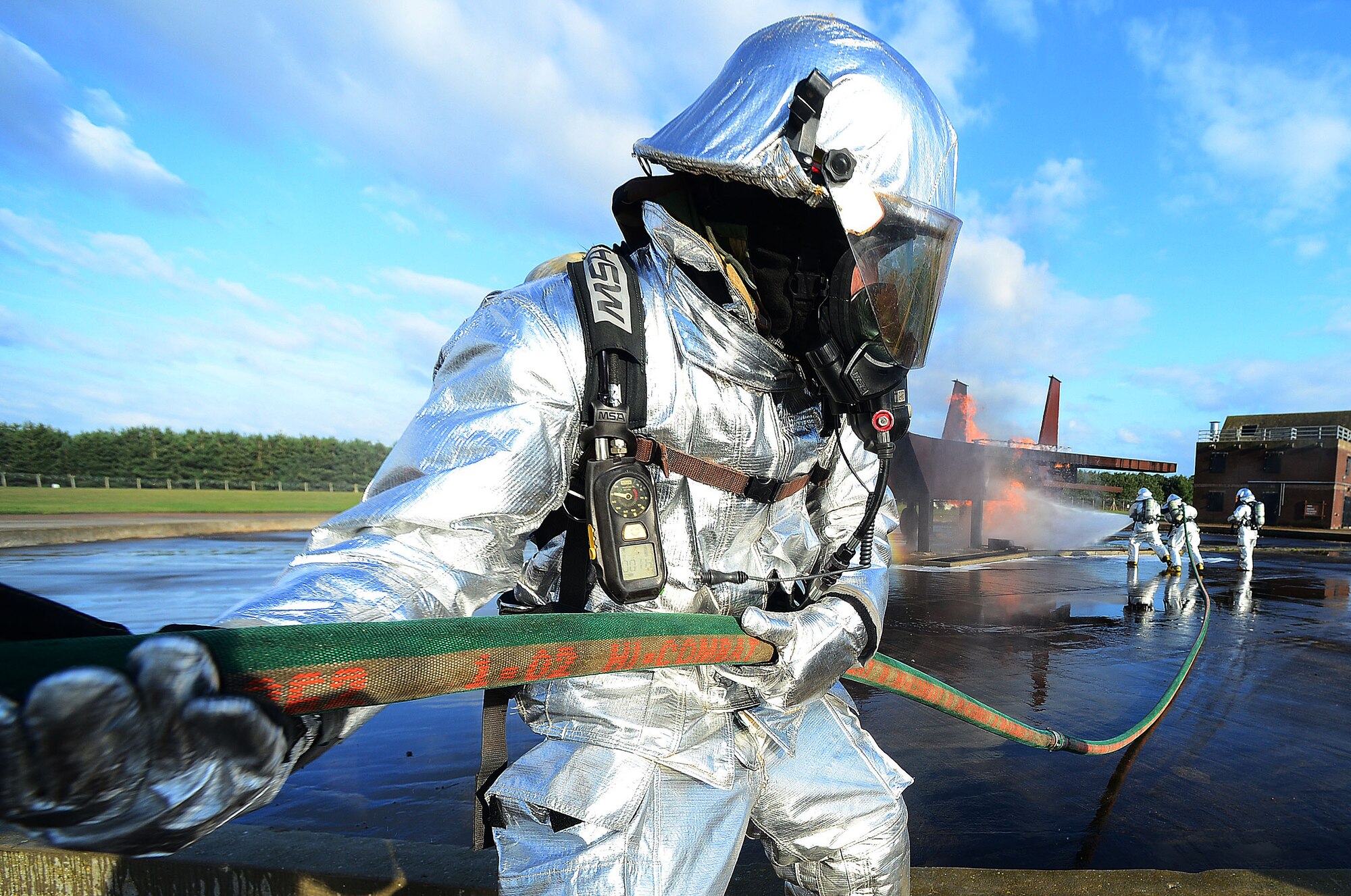 Firefighters of the 48th Civil Engineer Squadron extinguish a mock F-15 aircraft fire at the fire training pit at Royal Air Force Lakenheath, England, Nov. 21, 2013. The base conducted a Phase II exercise to test deployed response capabilities of Airmen through various scenarios to ensure mission readiness.  (U.S. Air Force photo by Senior Airman Tiffany M. Grigg/Released)