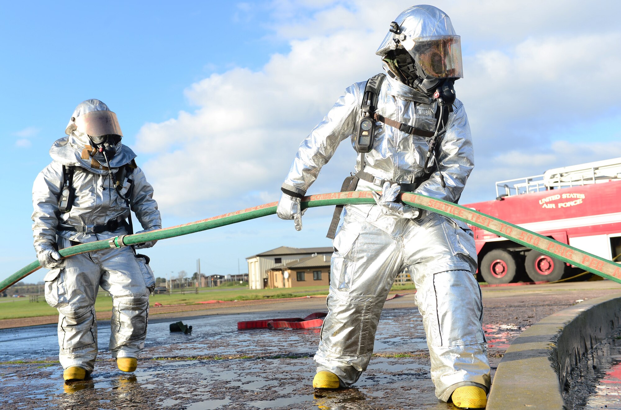Firefighters of the 48th Civil Engineer Squadron assist in extinguishing a simulated F-15 fighter jet crash fire during a Phase II exercise at Royal Air Force Lakenheath, England, Nov. 21, 2013. One aspect the Phase II was testing the response capabilities of Airmen through various scenarios to ensure mission readiness. (U.S. Air Force photo by Airman 1st Class Dawn M. Weber/Released)