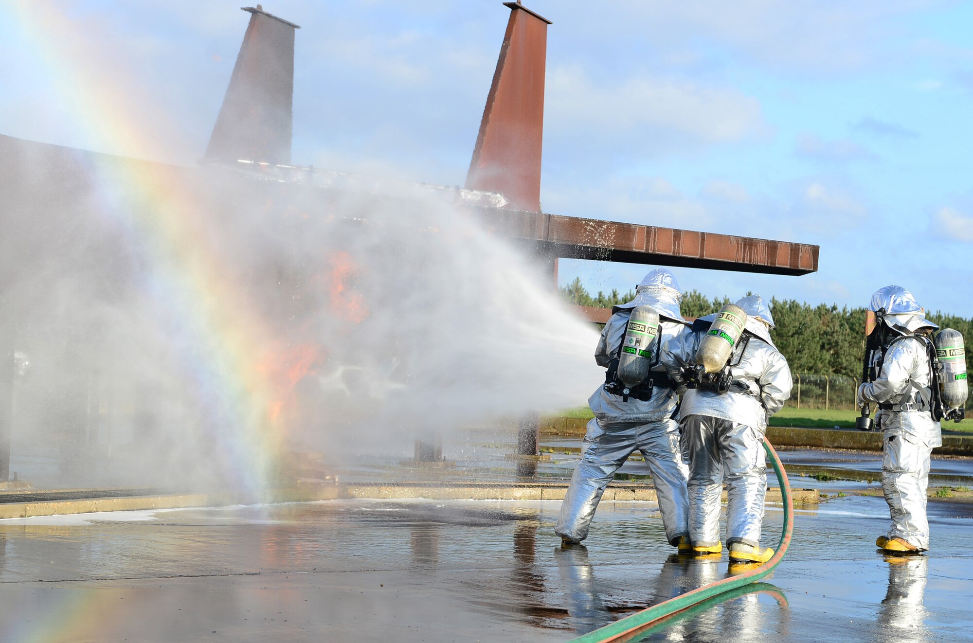 Firefighters of the 48th Civil Engineer Squadron extinguish a simulated F-15 fighter jet crash fire during a Phase II exercise at Royal Air Force Lakenheath, England, Nov. 21, 2013. One aspect the Phase II was testing the response capabilities of Airmen through various scenarios to ensure mission readiness. (U.S. Air Force photo by Airman 1st Class Dawn M. Weber/Released)