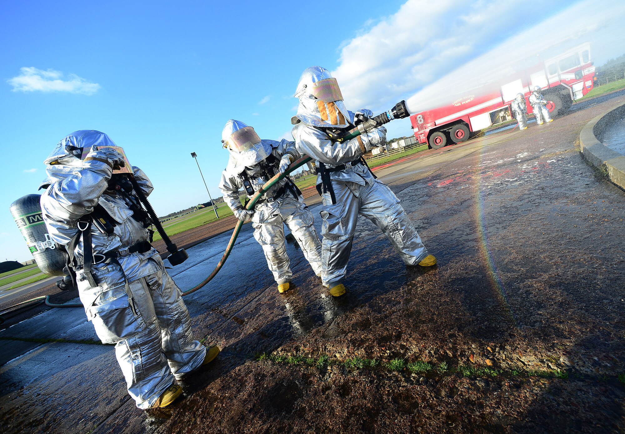 Firefighters of the 48th Civil Engineer Squadron extinguish a mock F-15 aircraft at the fire training pit at Royal Air Force Lakenheath, England, Nov. 21, 2013.  The Phase II exercise tested the 48th Fighter Wing’s readiness to support contingency operations.  (U.S. Air Force photo by Senior Airman Tiffany M. Grigg/Released)