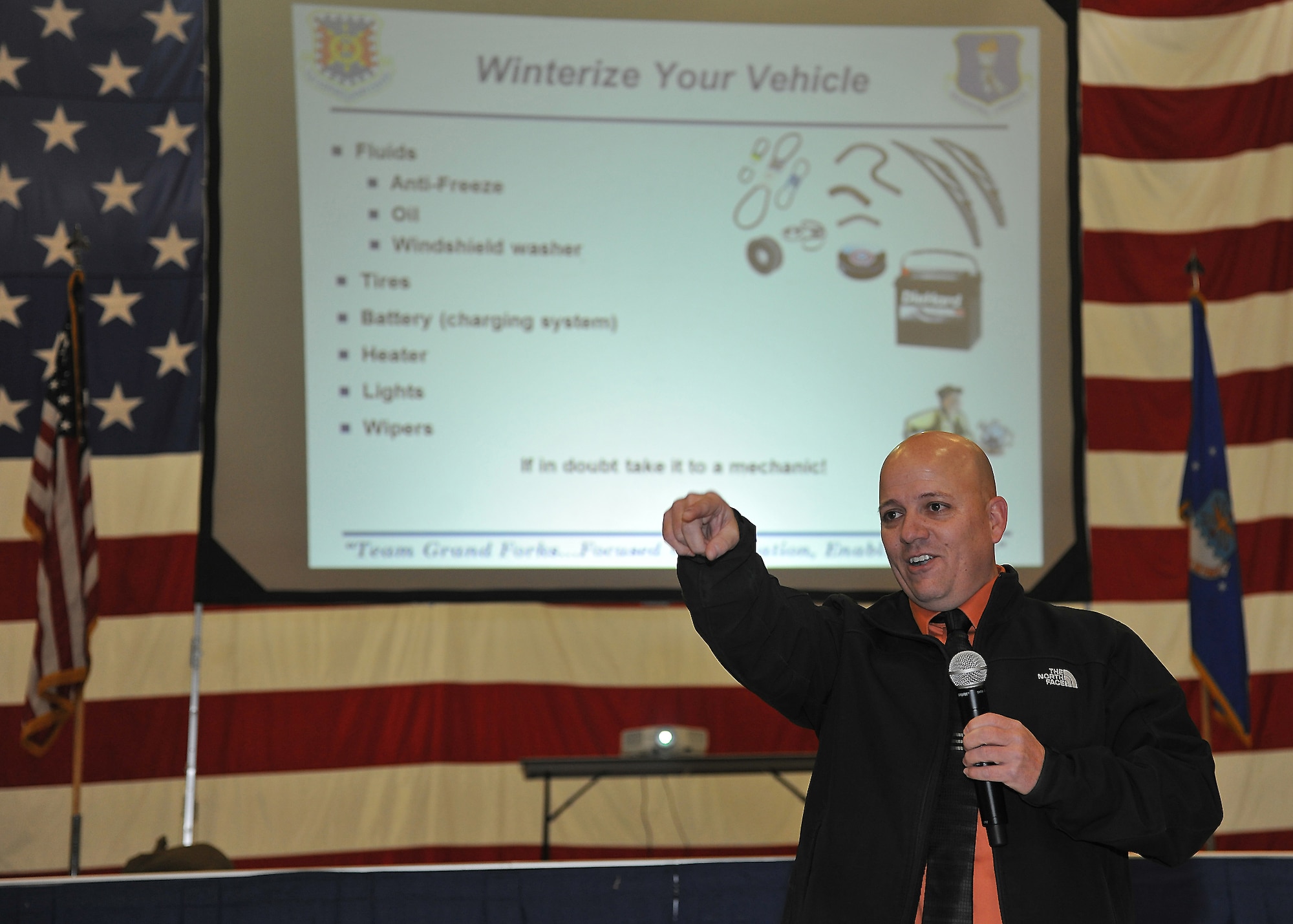 Andrew Swenson, 319th Air Base Wing ground safety manager, speaks about winter safety precautions and tips during a wing All Call on Grand Forks Air Force Base, N.D., Nov. 15, 2013. Swenson stressed the importance of having a fully charged cell phone in emergency kits as they can be life-saving in most situations. (U.S. Air Force photo/Senior Airman Xavier Navarro)