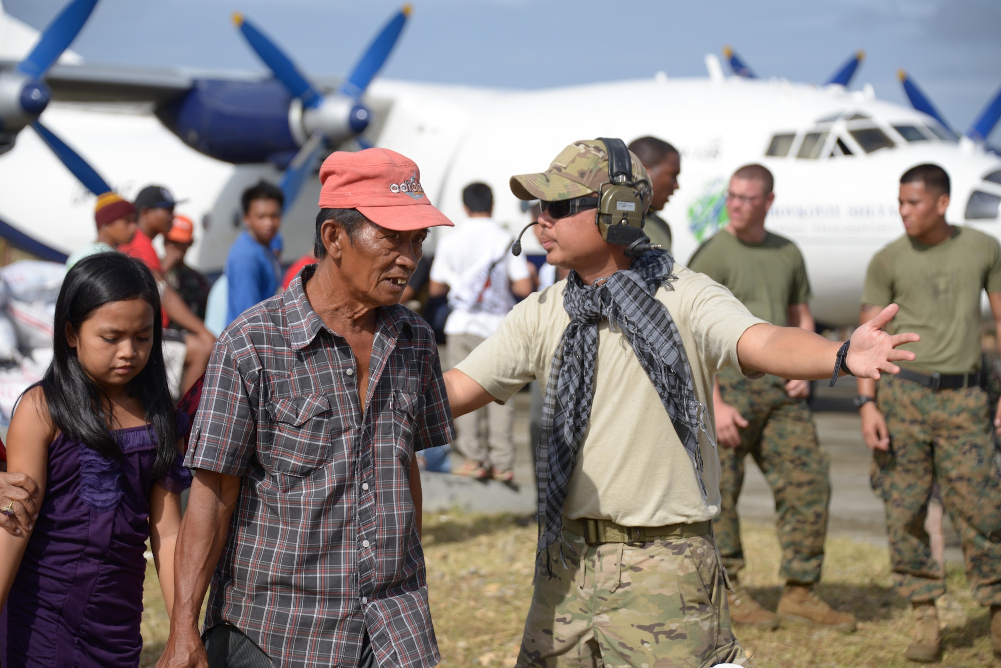 Staff Sgt. Antonio Garcia, 353rd Special Operations Group, directs Filipino passengers to the aircraft Nov. 17, at Guiuan Airport. Air Force Special Operations Command Airmen are deployed in support of Operation Damayan. Garcia, assigned to the 353rd SOG as a vehicle maintainer, served as a translator during this mission. (U.S. Air Force photo by Tech. Sgt. Kristine Dreyer)  